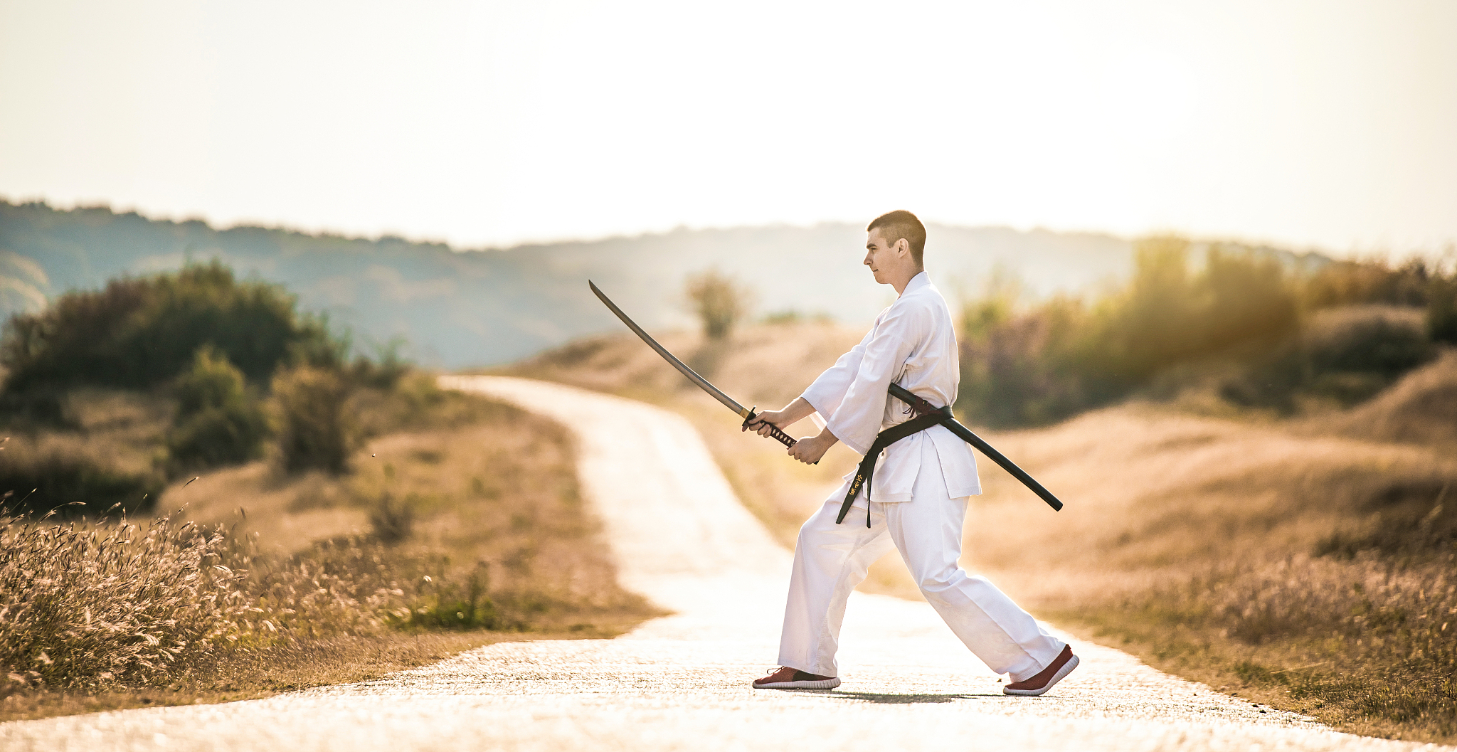 young martial artist practicing his skills with a katana sword.