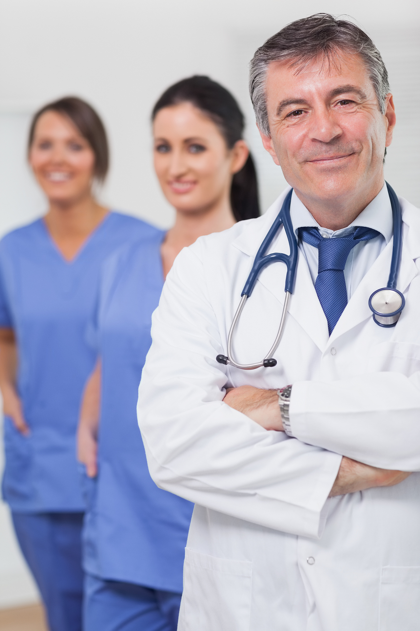 doctor with arms crossed and his team of nurses