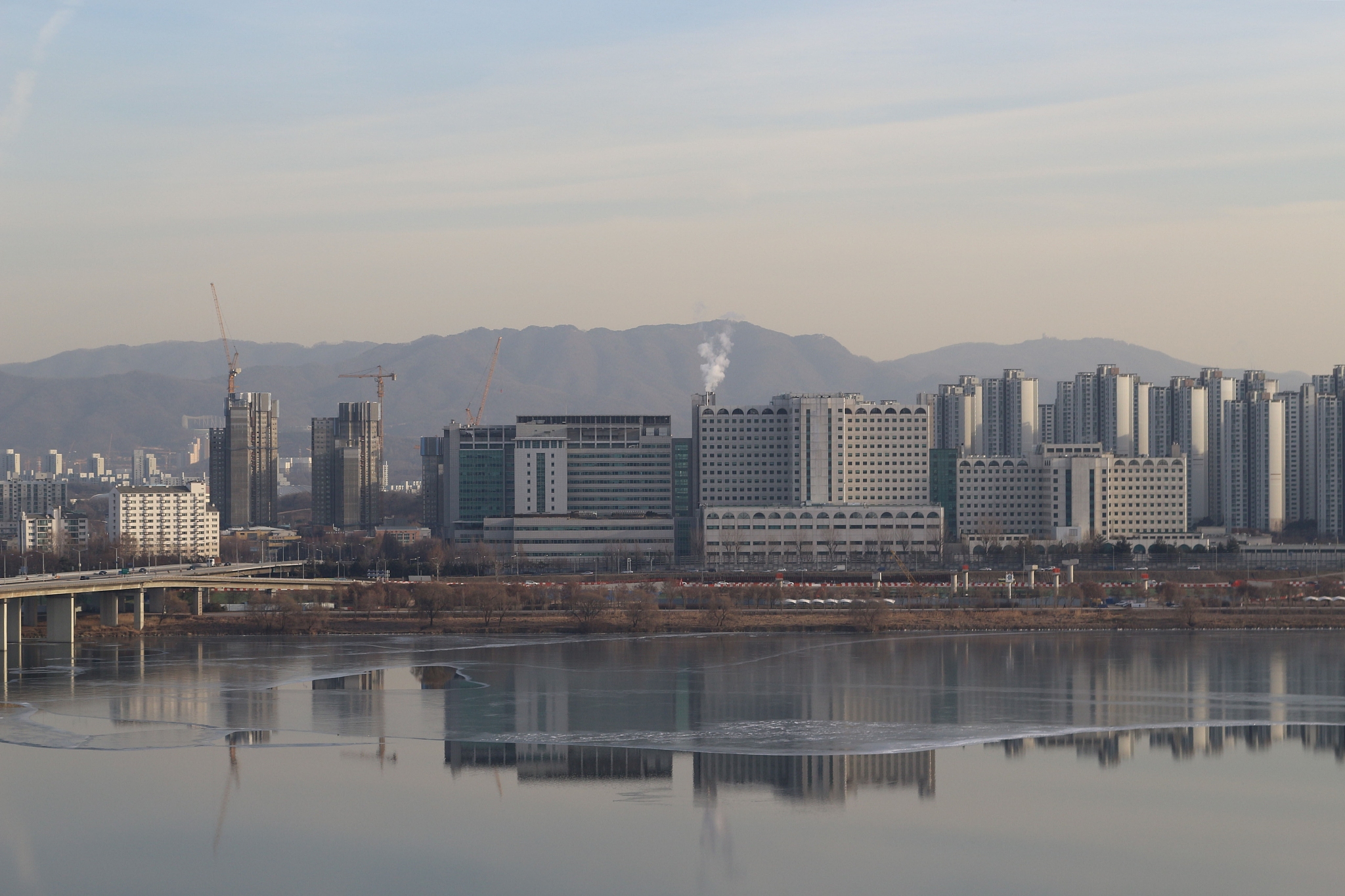 the frozen river and many buildings in the city in the winter. s