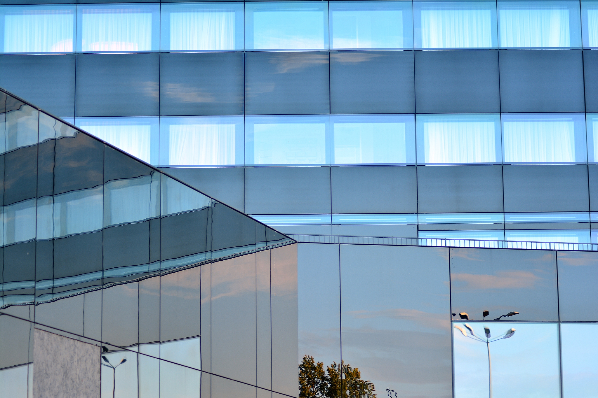 sky and clouds reflecting on a building with mirrored glass