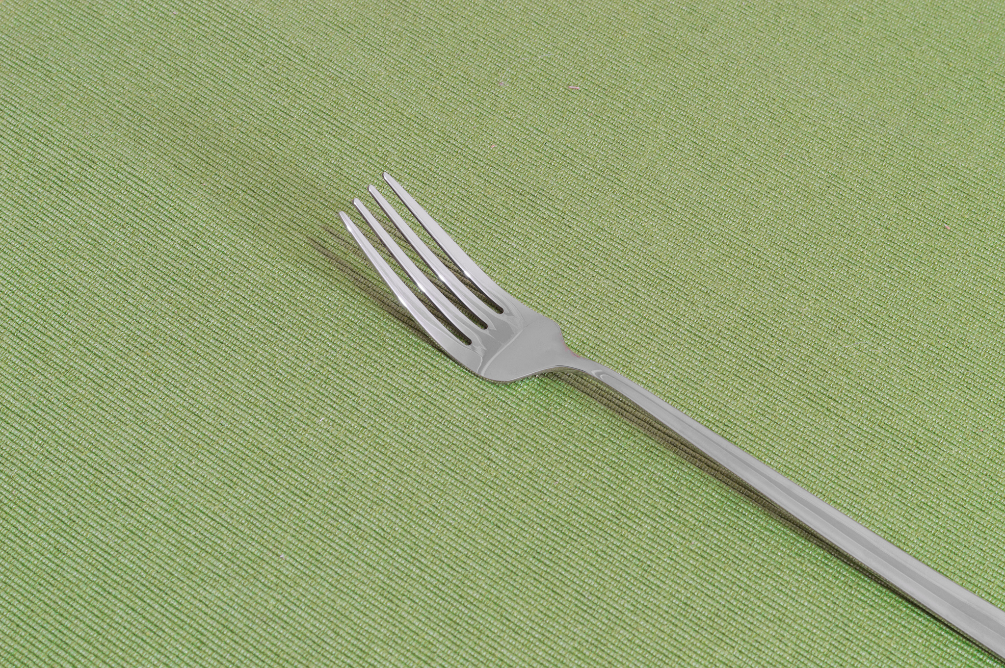 one fork on a green sheet with copy space