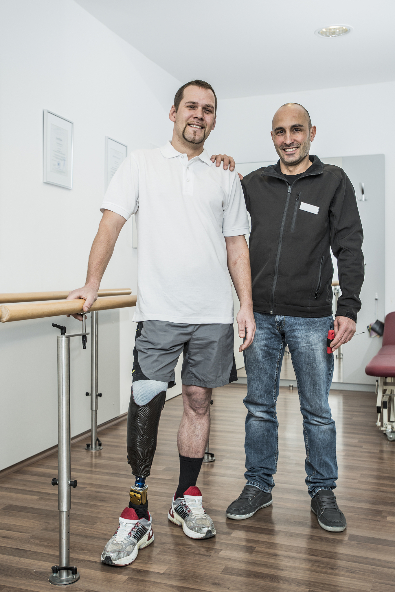 man with a prosthetic leg and physical therapist