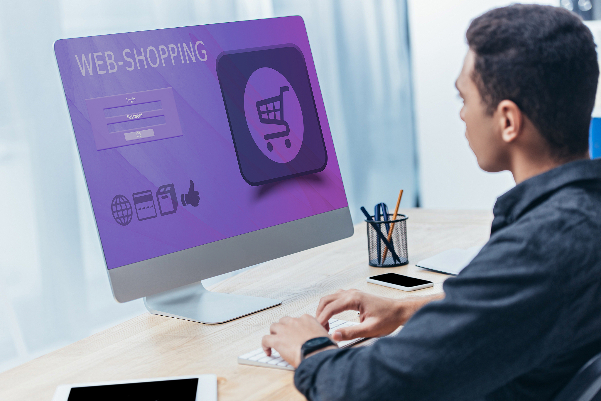 young businessman using desktop computer with shopping website o
