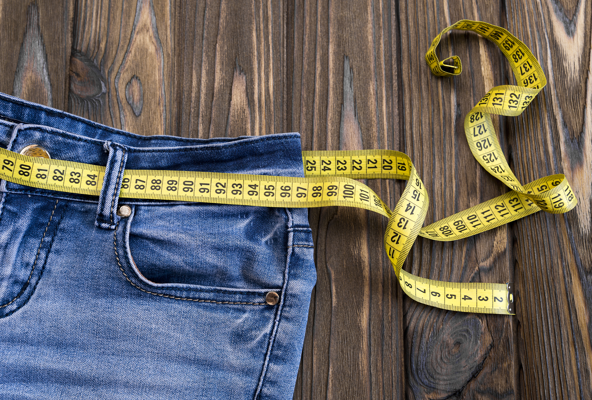 jeans, centimeter on a wooden background. diet. waist