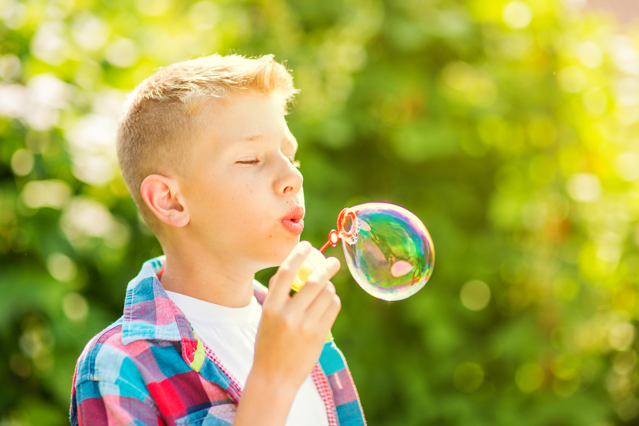 portrait of a young boy blowing soap bubbles