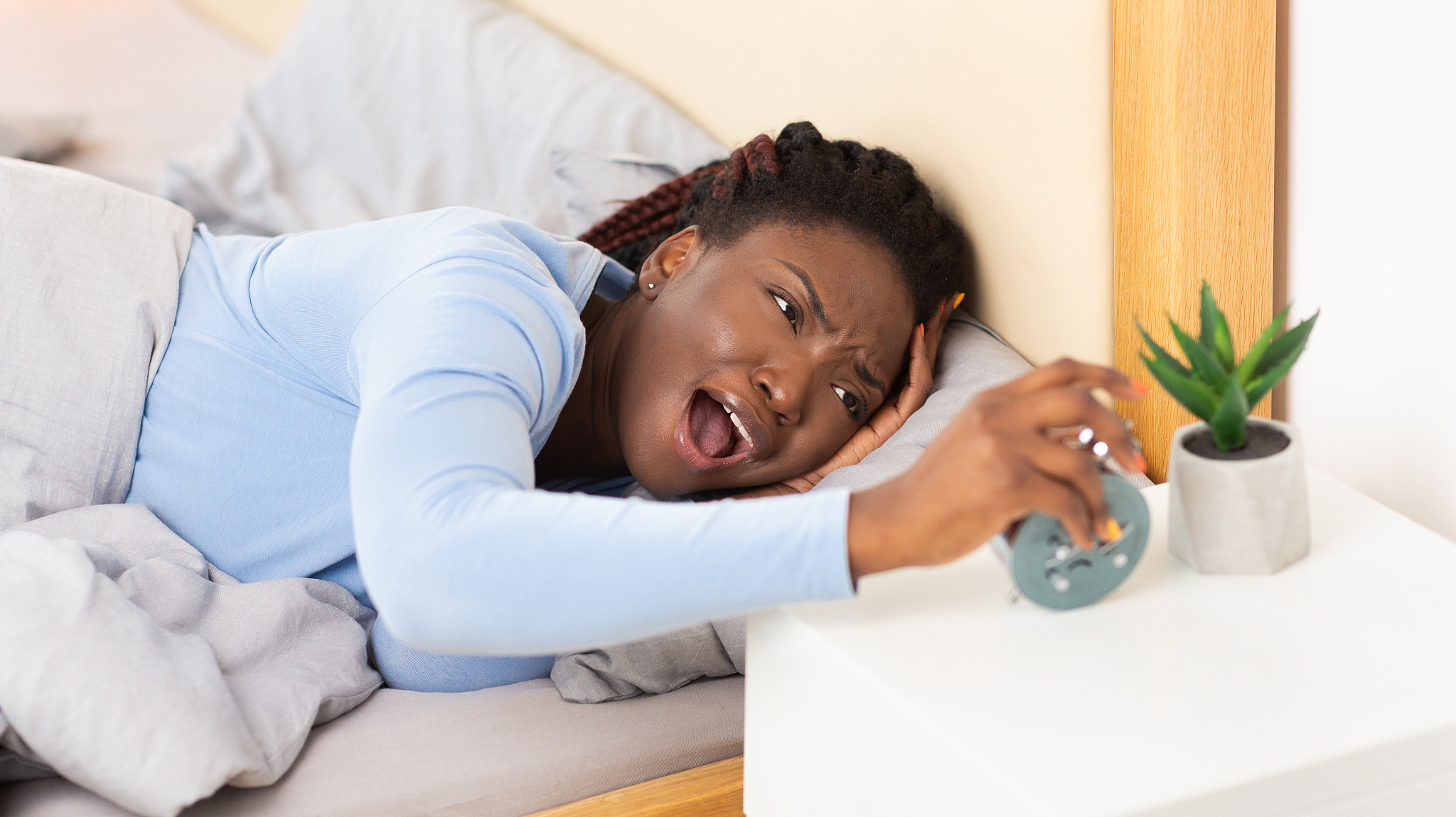 girl having a hard time waking up lying in bed