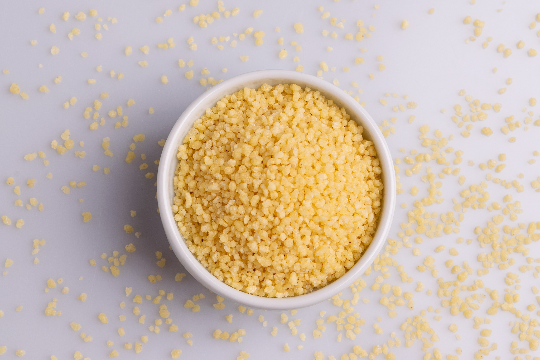 dry couscous isolated on white background, soft light, copy spac