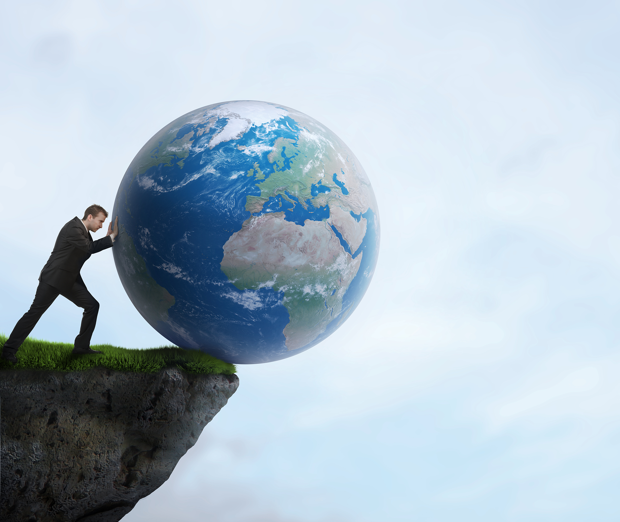 businessman pushing planet earth off a cliff