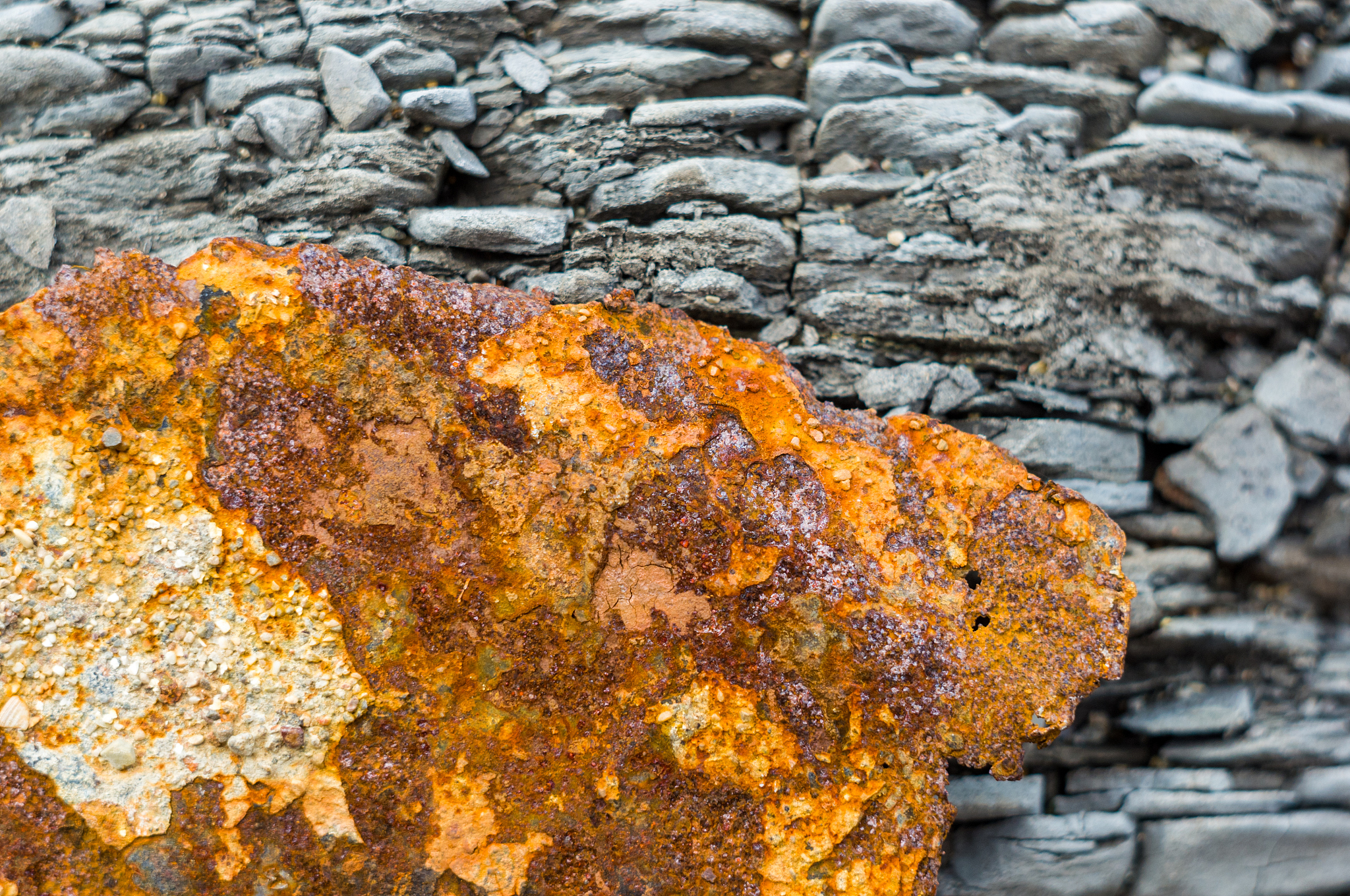 very rusty metal on a gray cracked rock