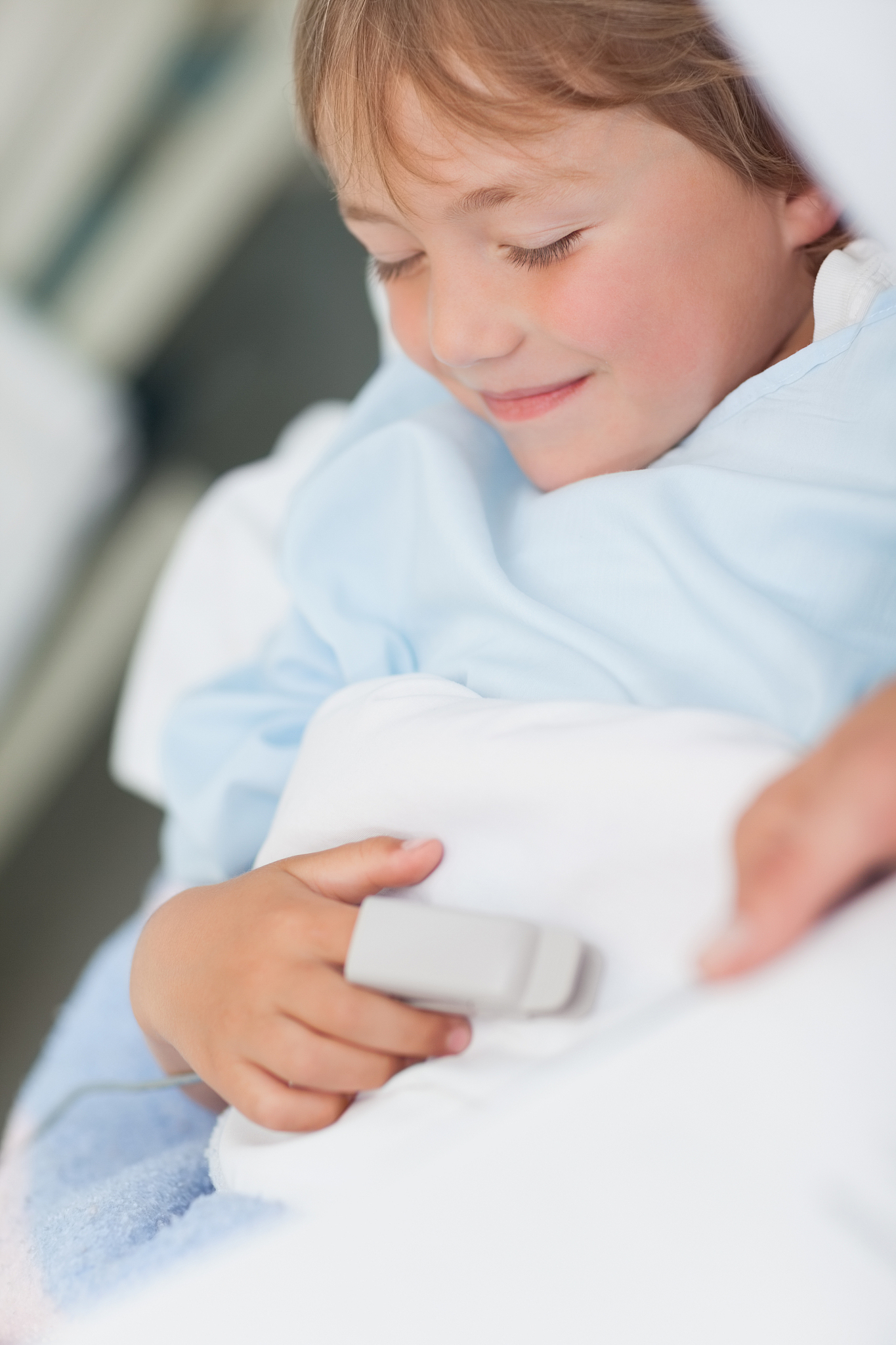 smiling child lying on a medical bed in hospital ward