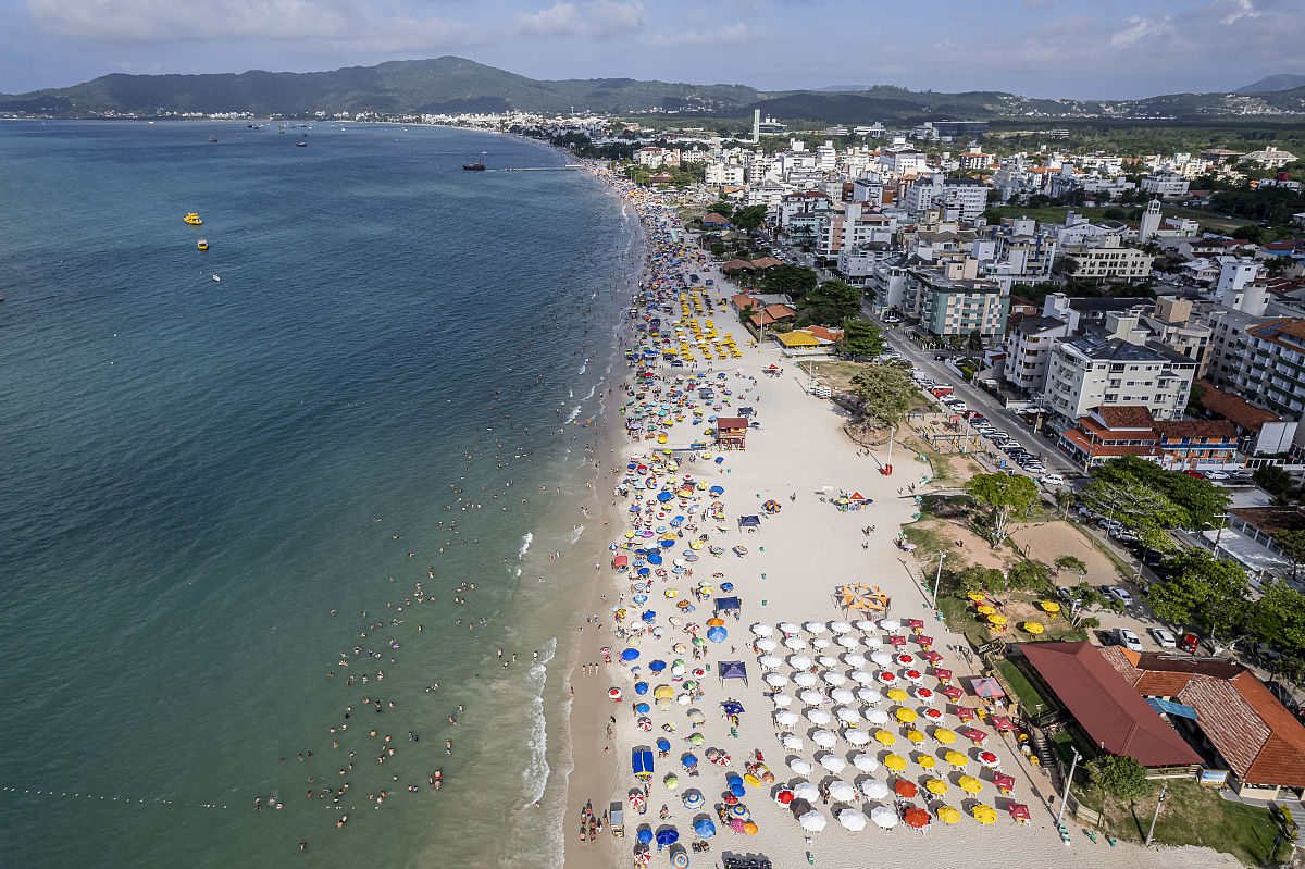 市区沙滩,有伞,沙滩宽条状,海水碧绿