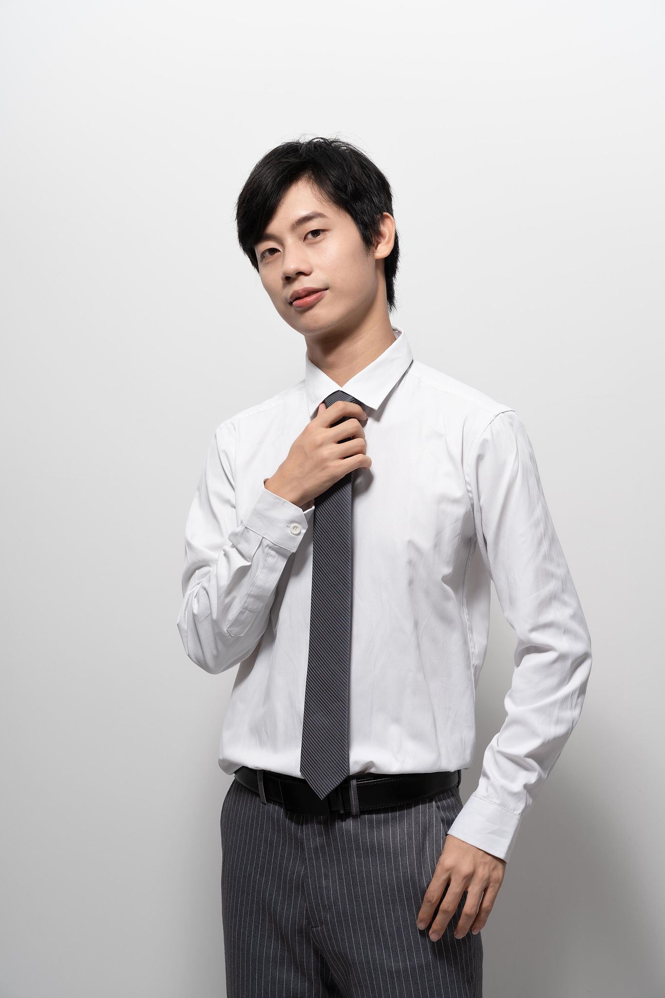 白色背景前穿衬衫戴领带的男人
