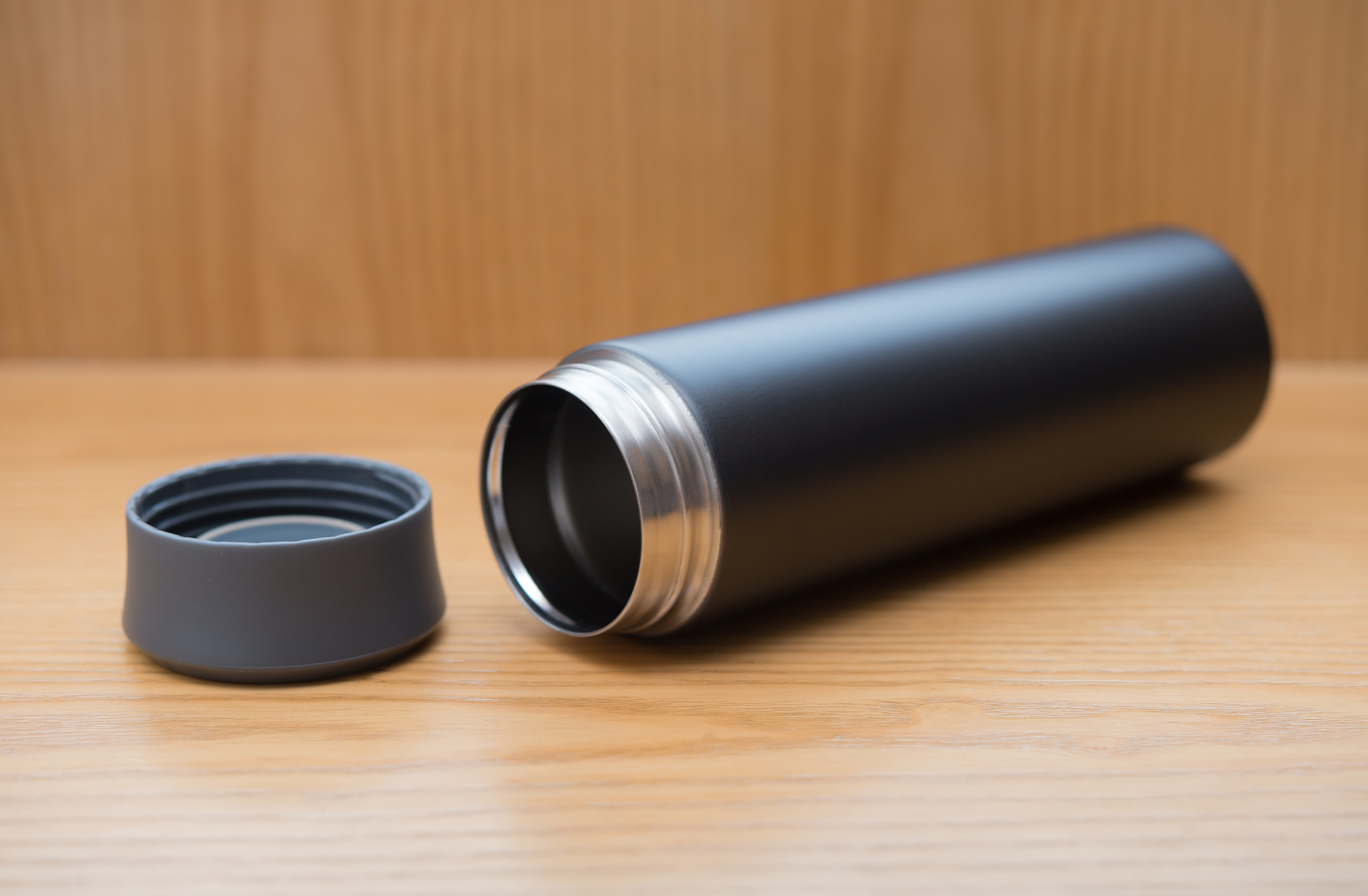 black vacuum tumbler on a wood table