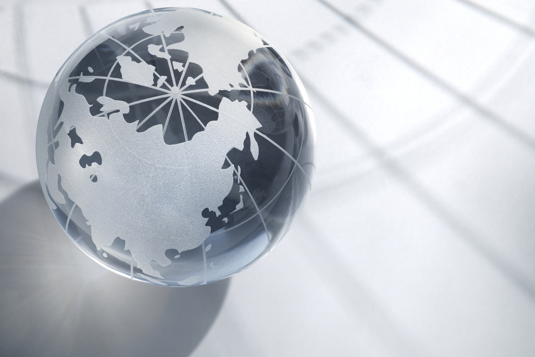 crystal globe turned toward asia on geographic background