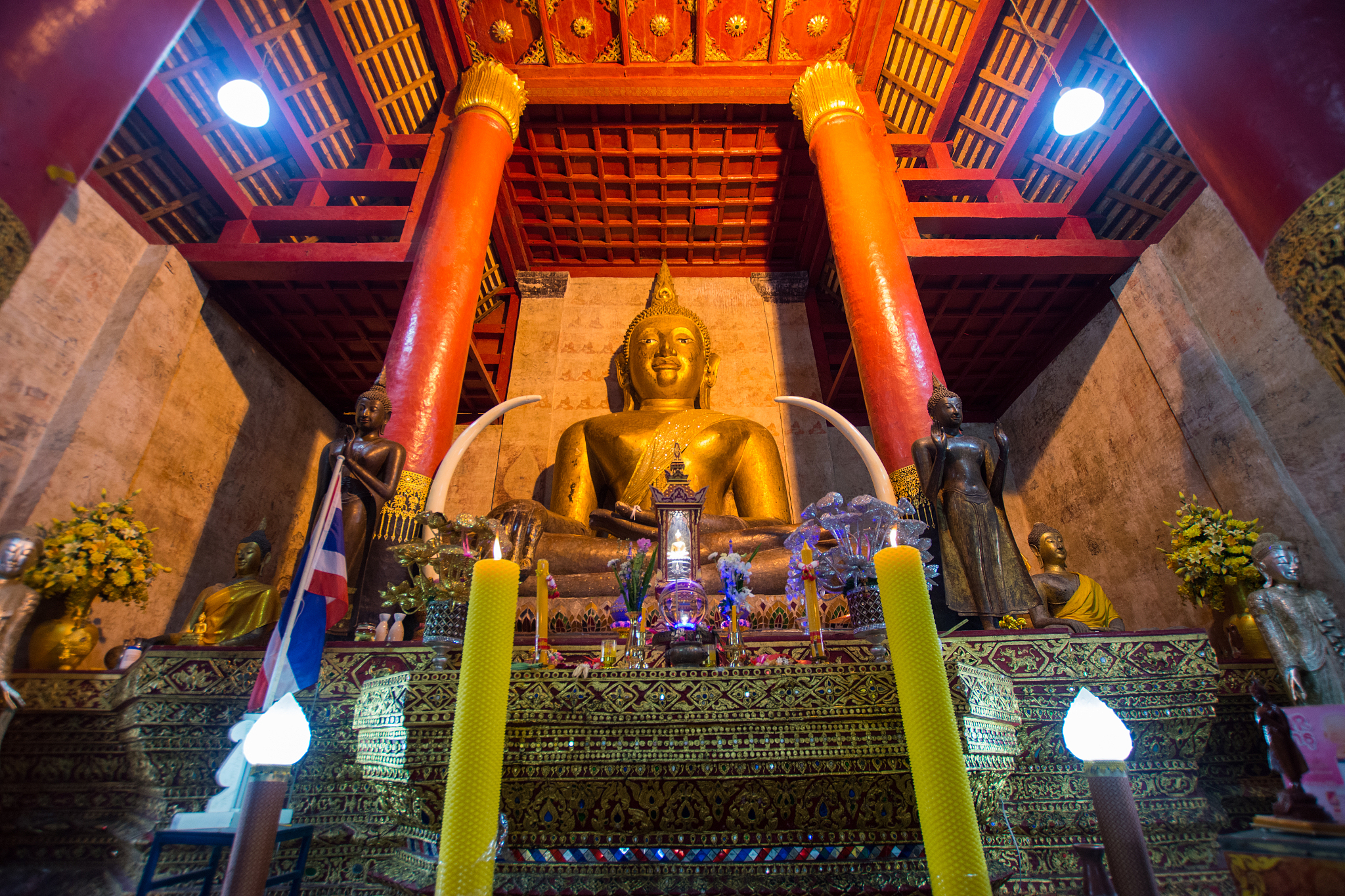 lit candles against buddha statue in temple