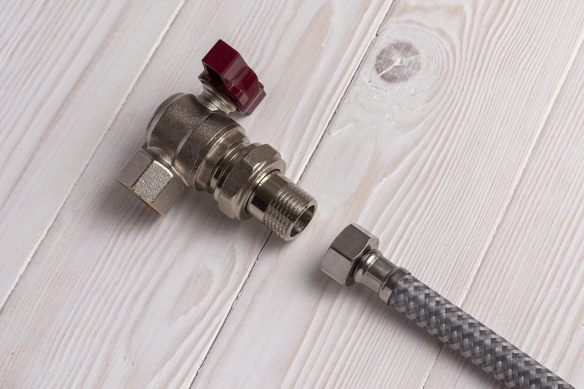 braided flexible water hose connecting to an angle water tap.