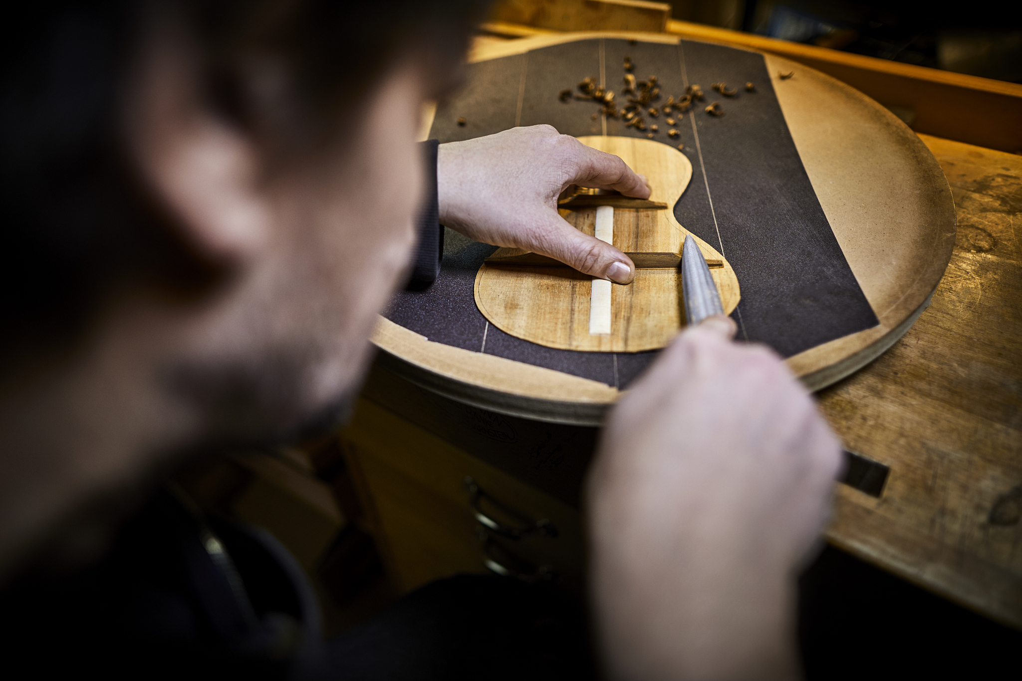 close-up of instrument maker working on stencil for an ukulele i