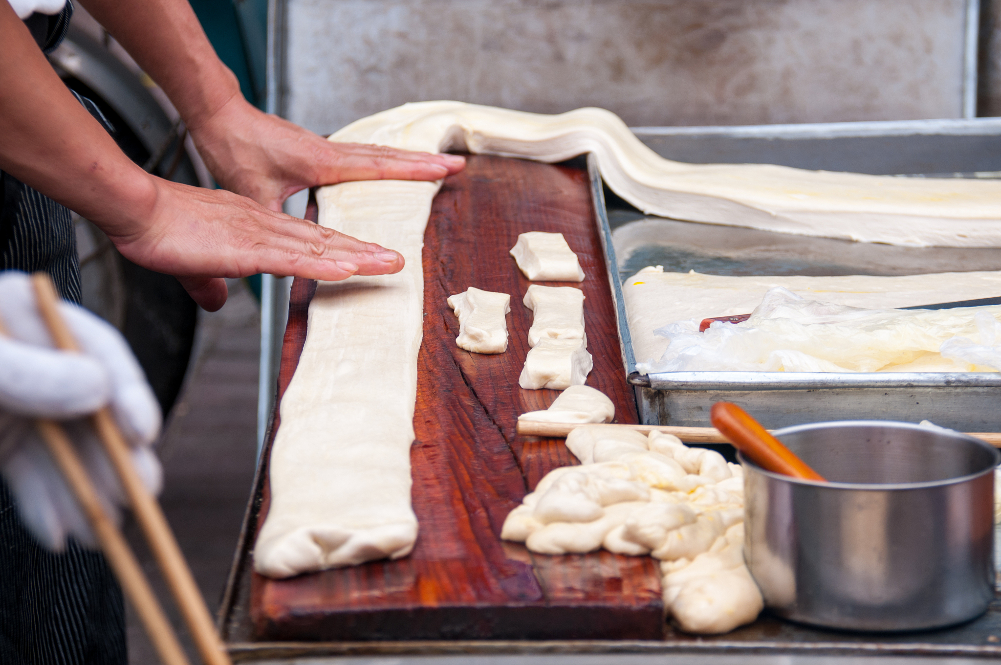 china, heihe, july 2019: a woman rolls dough at the market