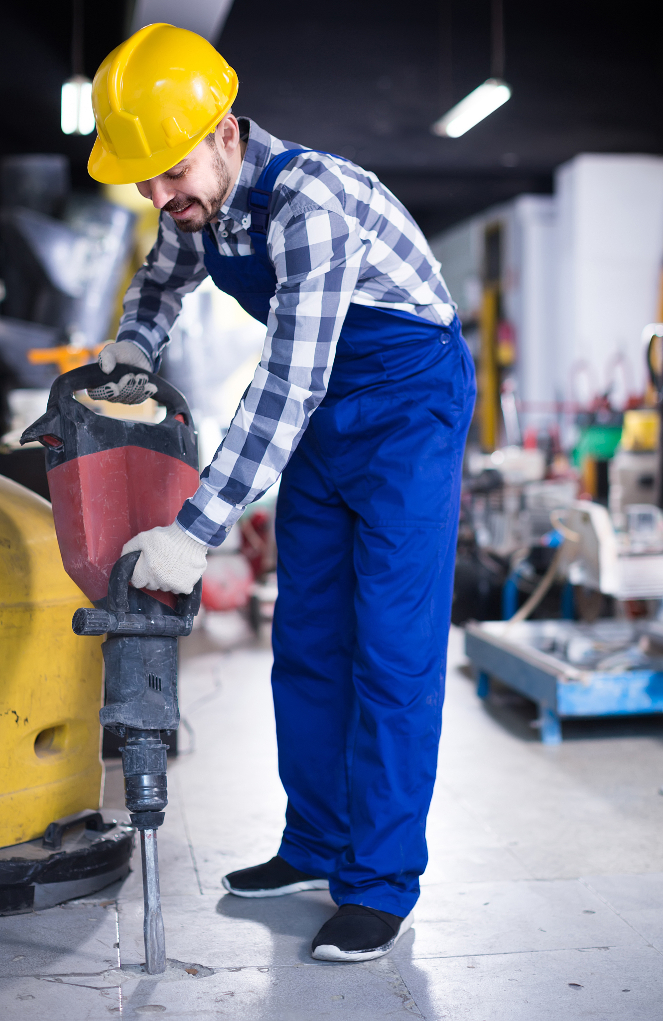 working man practicing his skills with pneumatic drill at worksh