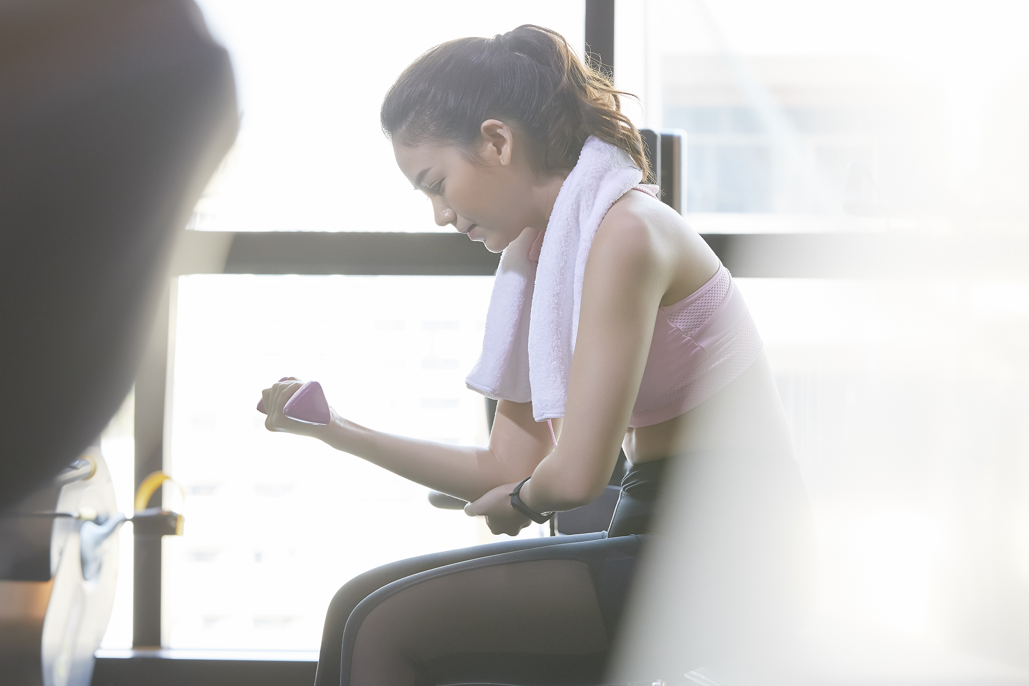一个亚洲女人弯下腰双臂夹紧看着镜头
