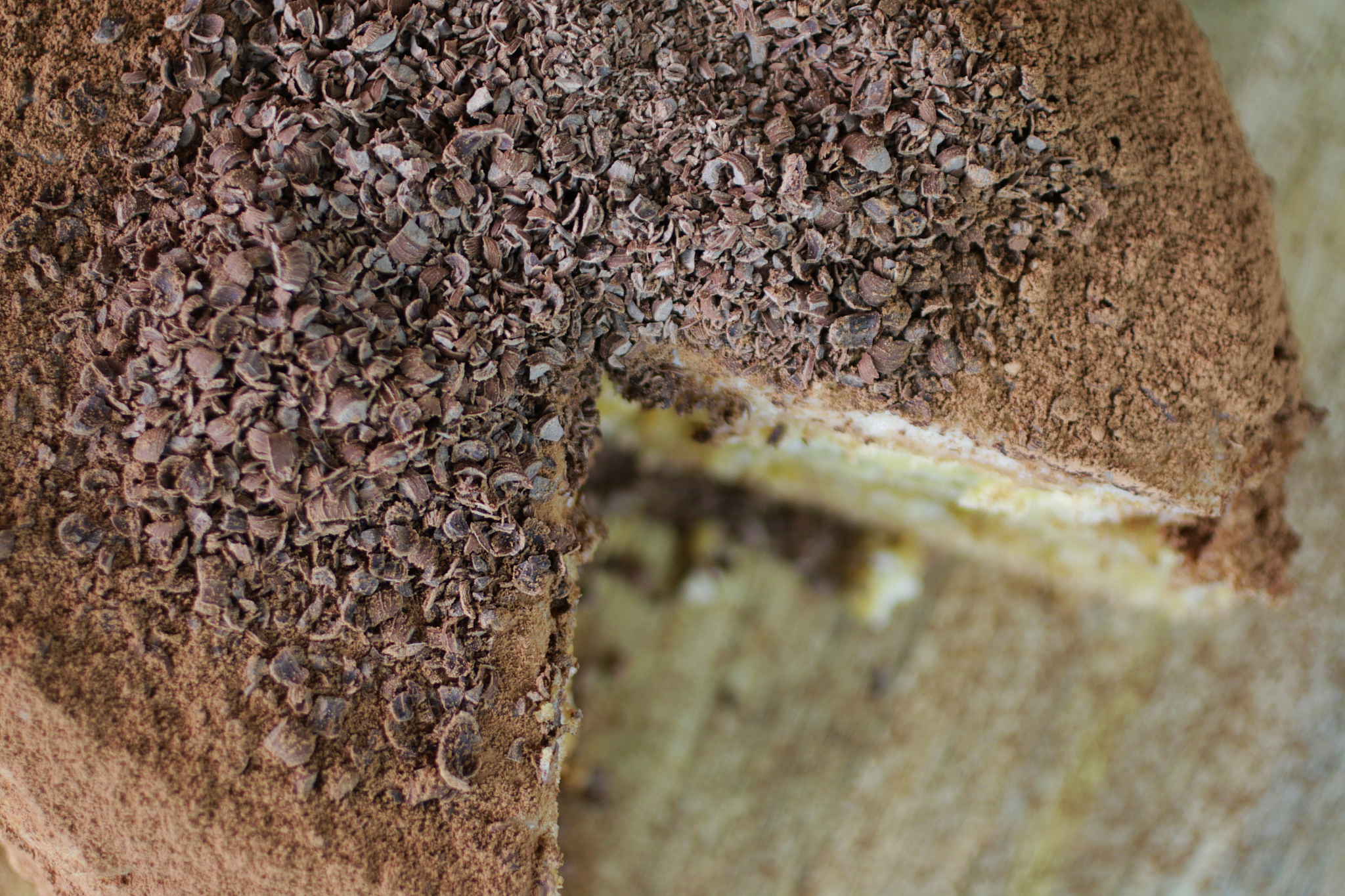 close-up image of sliced, layered coffee tiramisu cake topped wi