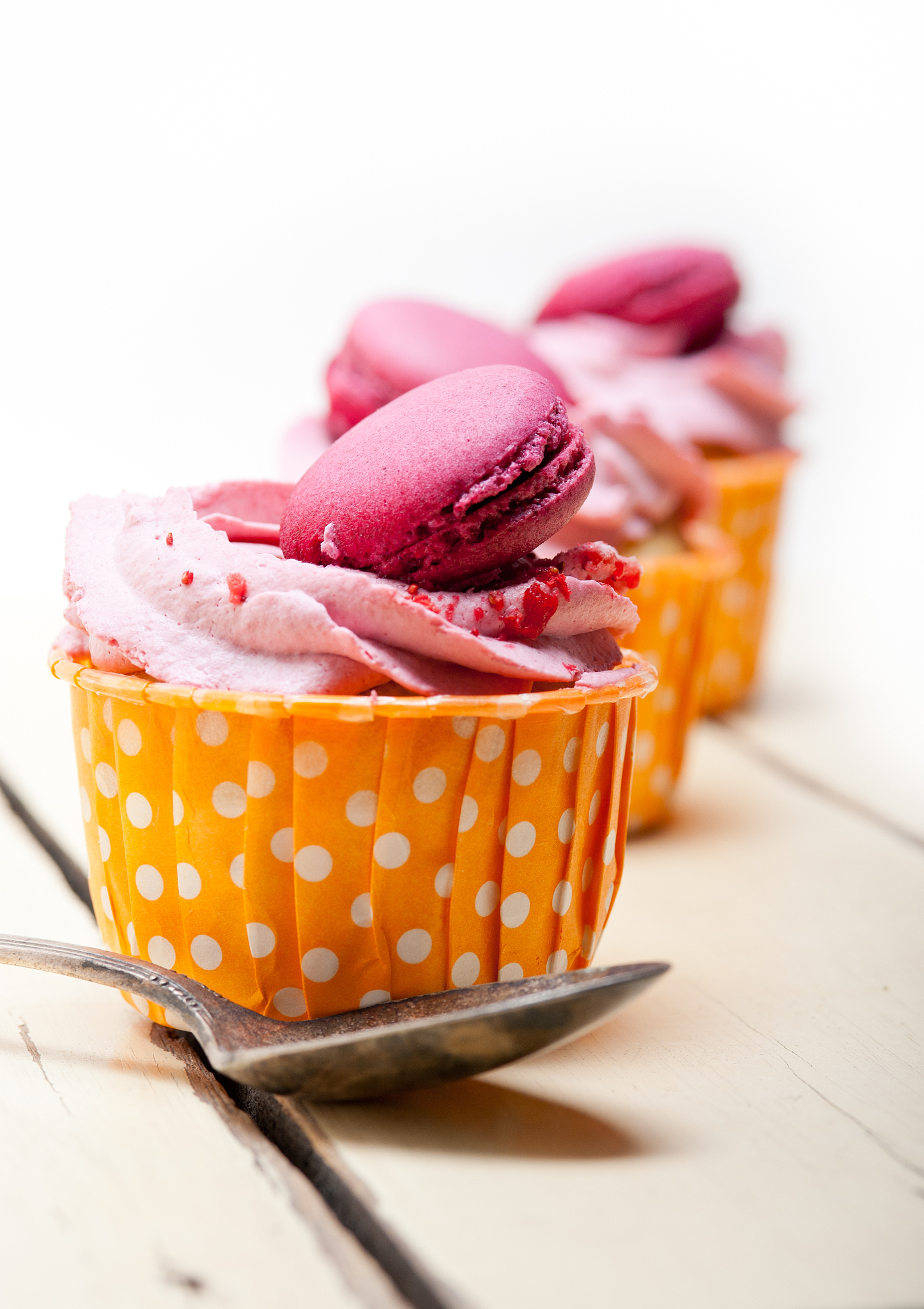 pink berry cream cupcake with macaroon on top