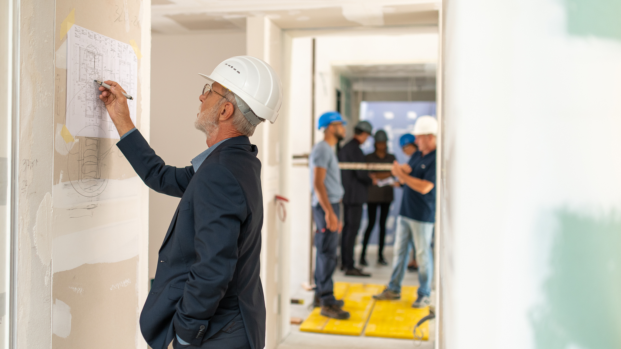 architect studying a blueprint on the wall