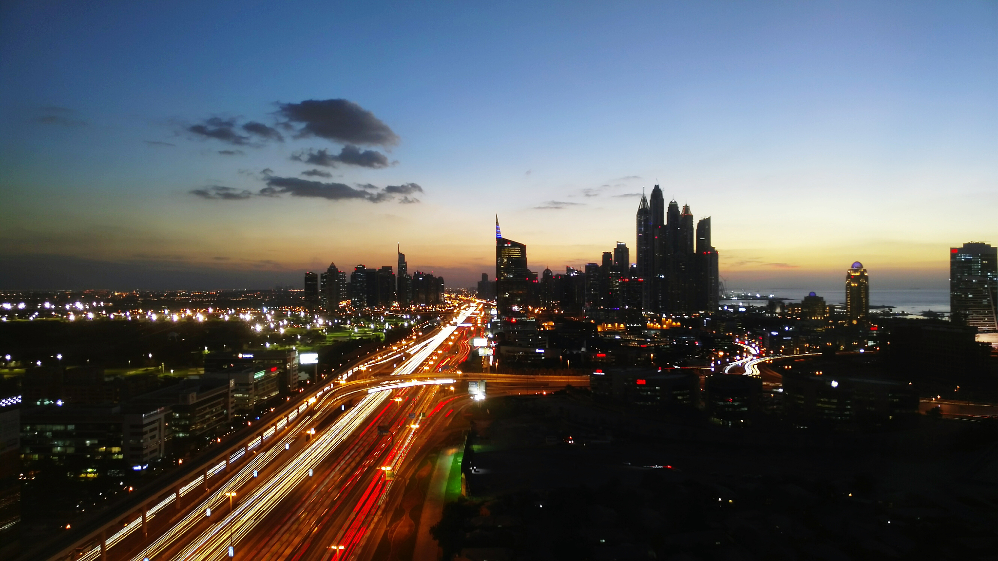 light trails on city street against sky at sunset