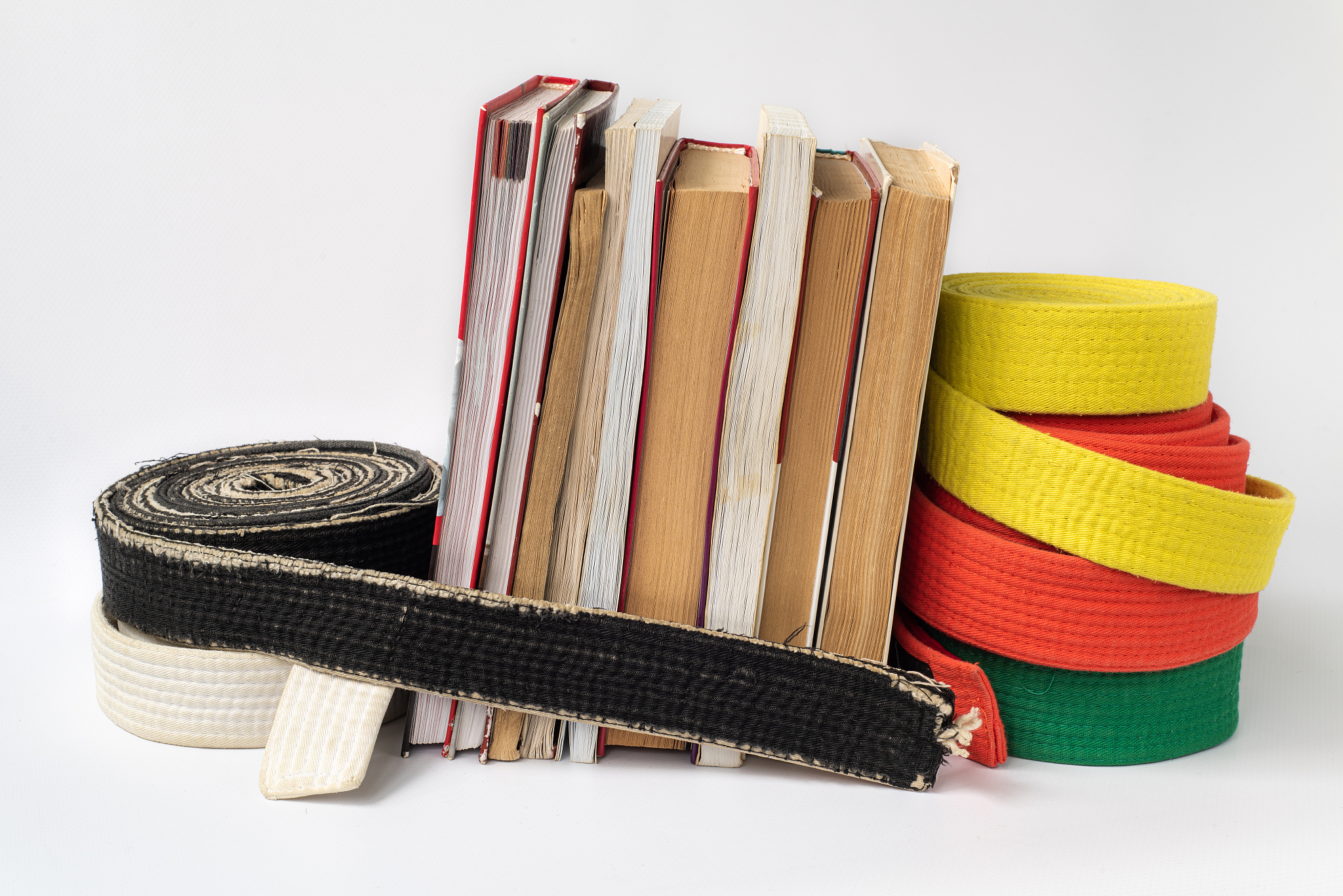 black and white martial arts belt on a stack of books on the stu