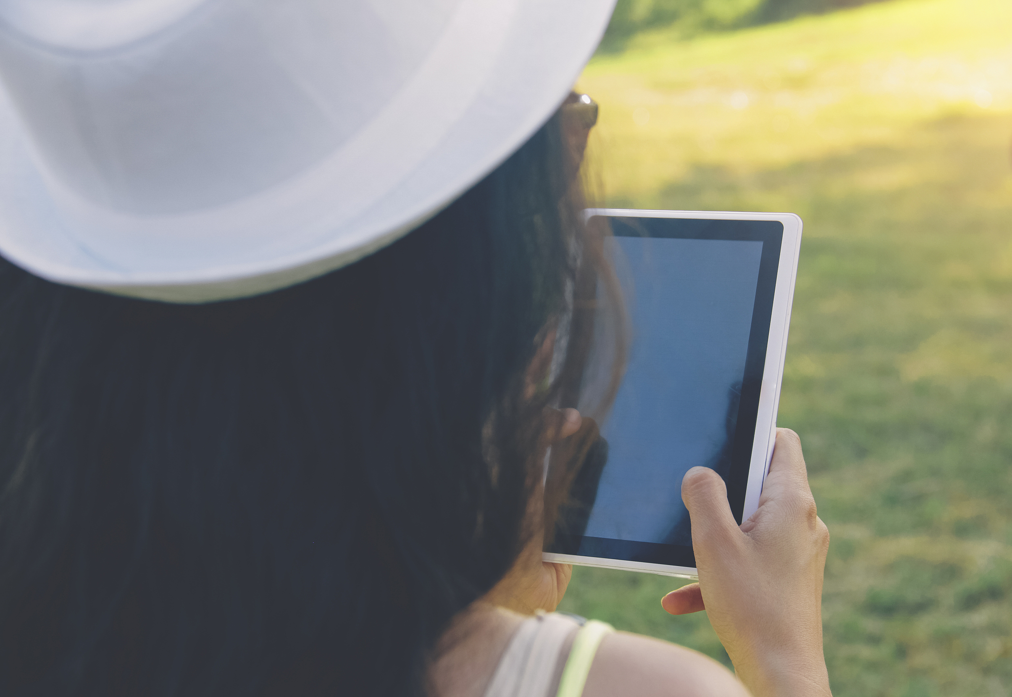 woman holds digital tablet, summer landscape