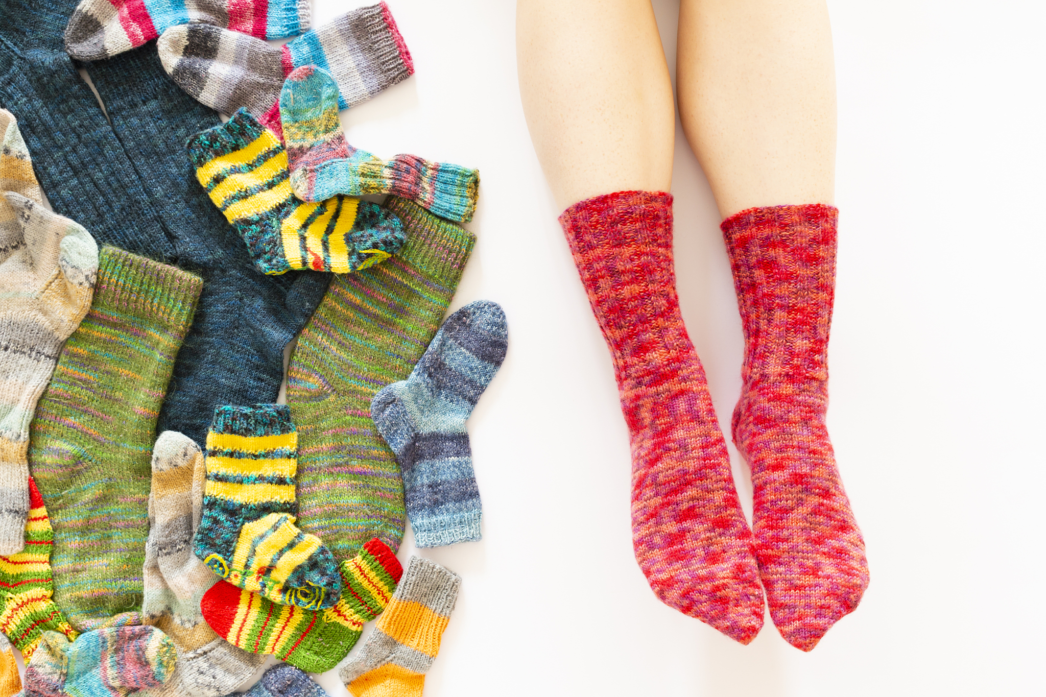 low section of person with multi colored socks against white bac