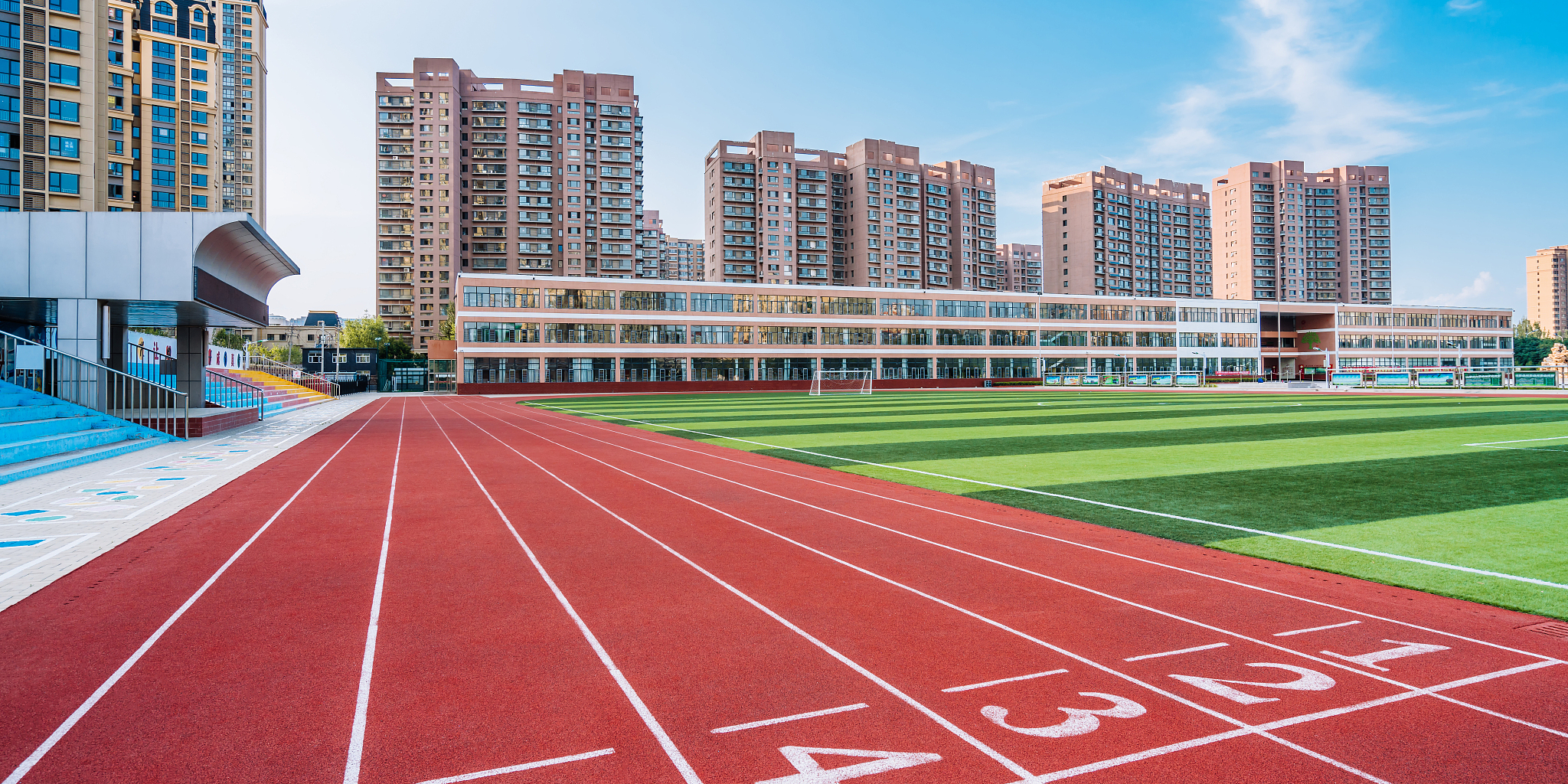 体育场的红色跑道和远处的高楼建筑