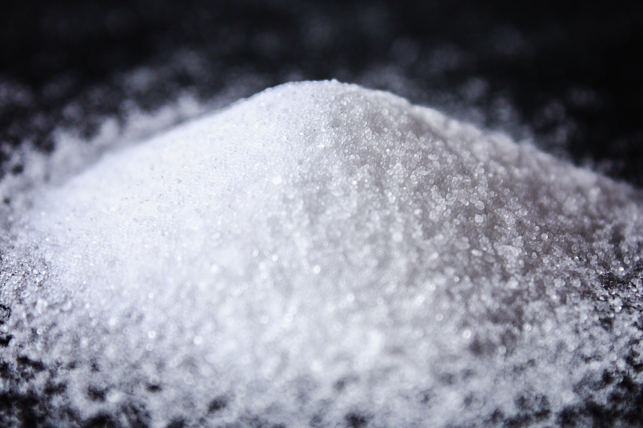 slides of small crystals of salt are scattered on a black table.
