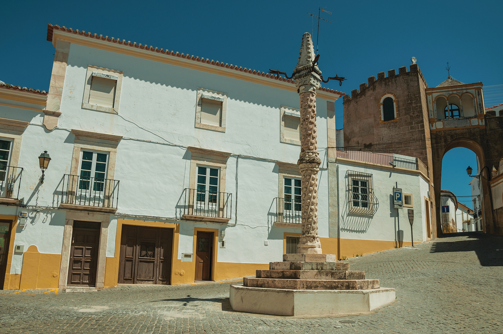 deserted square with marble pillory and old buildings