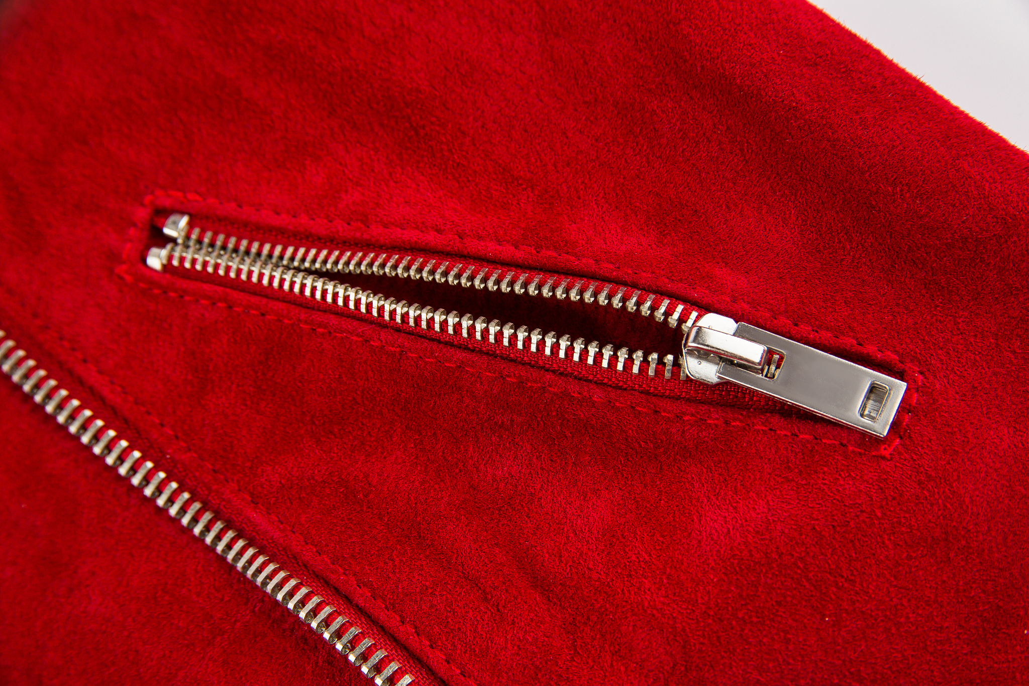 clothing elements, zipper and buttons on red suede