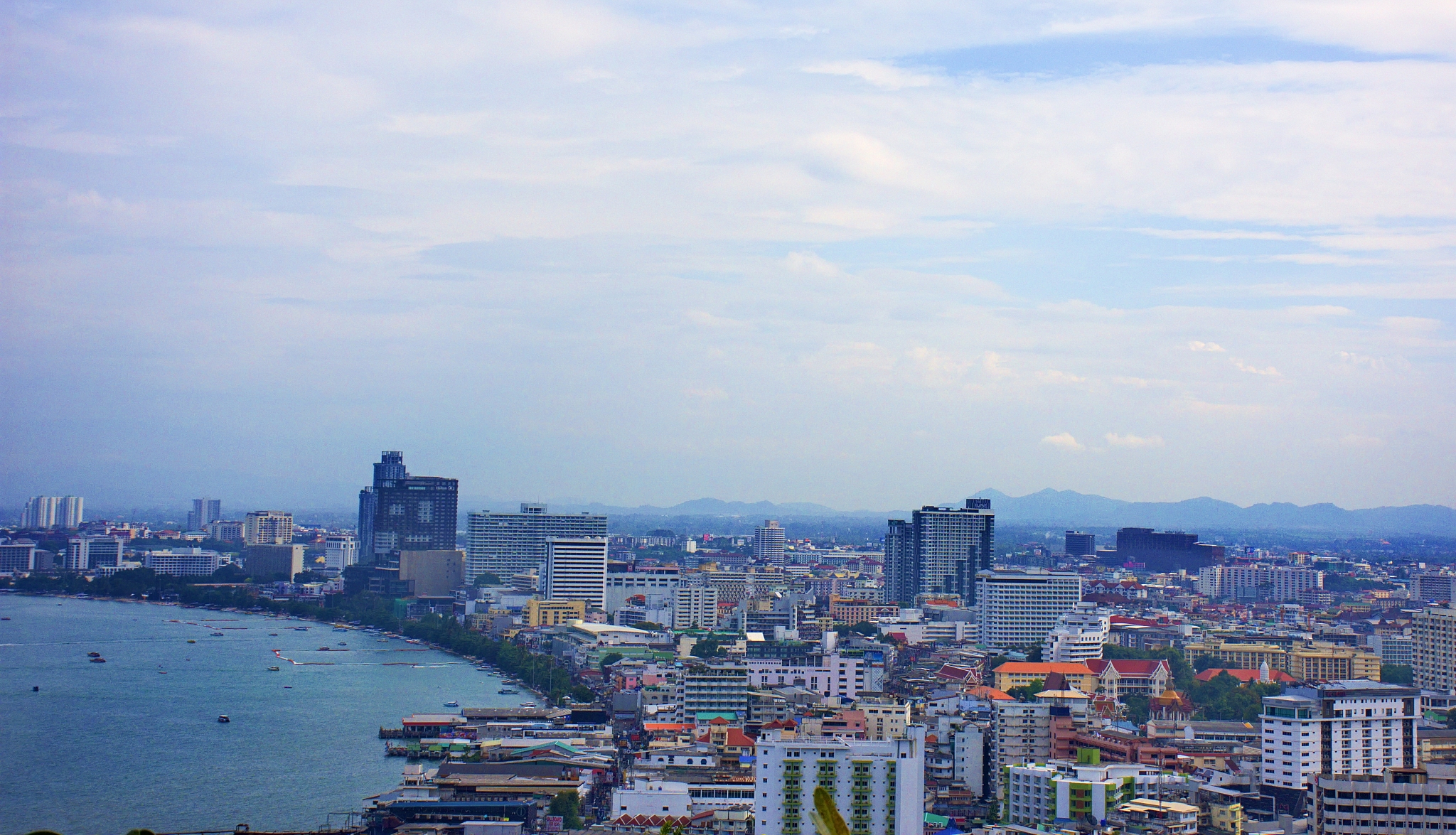 city at waterfront against cloudy sky