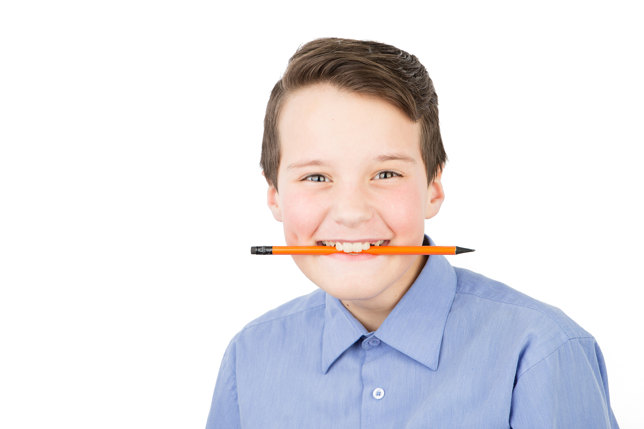 smiling schoolboy in a shirt with a pencil
