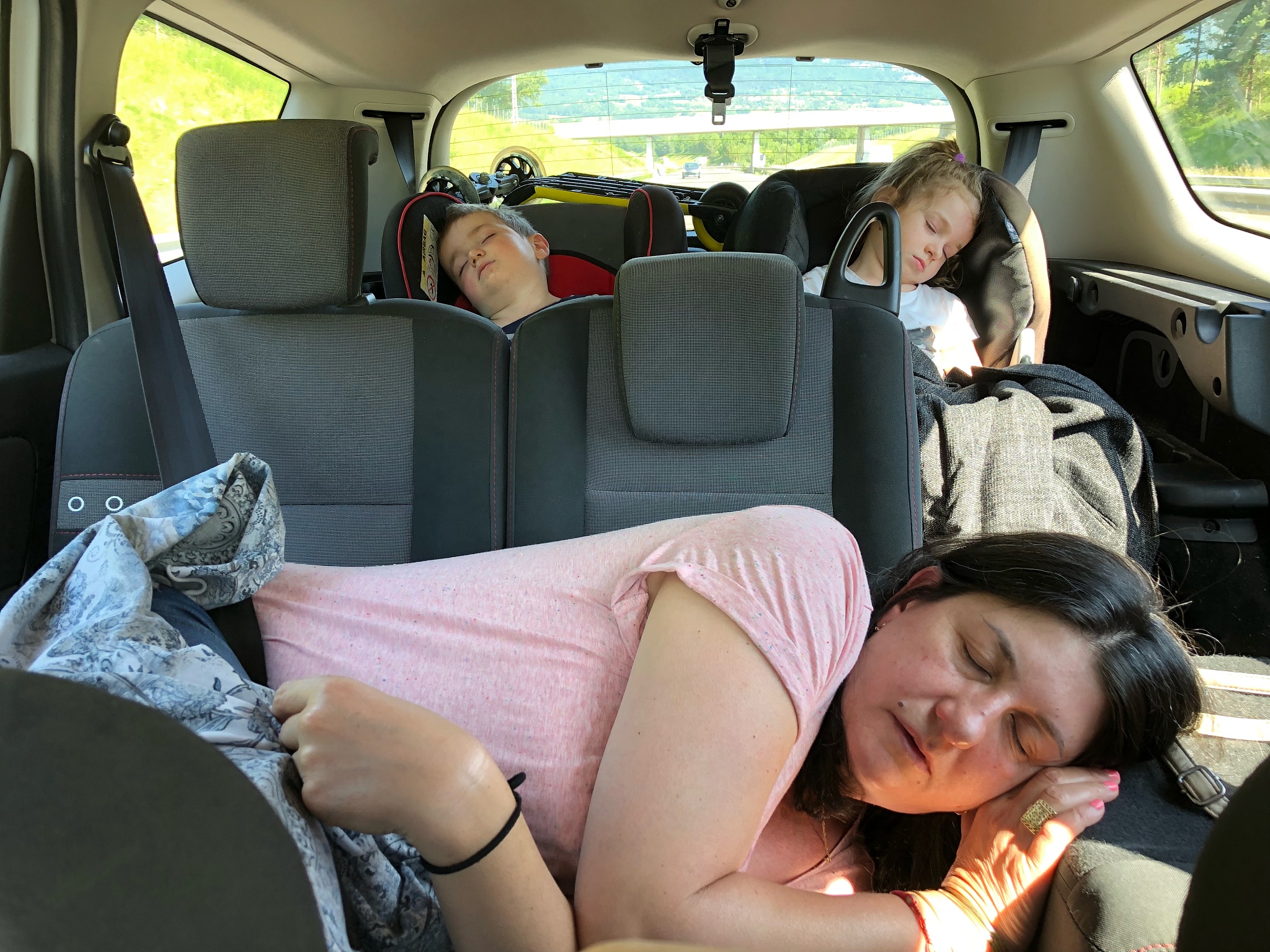 family sleeping in car