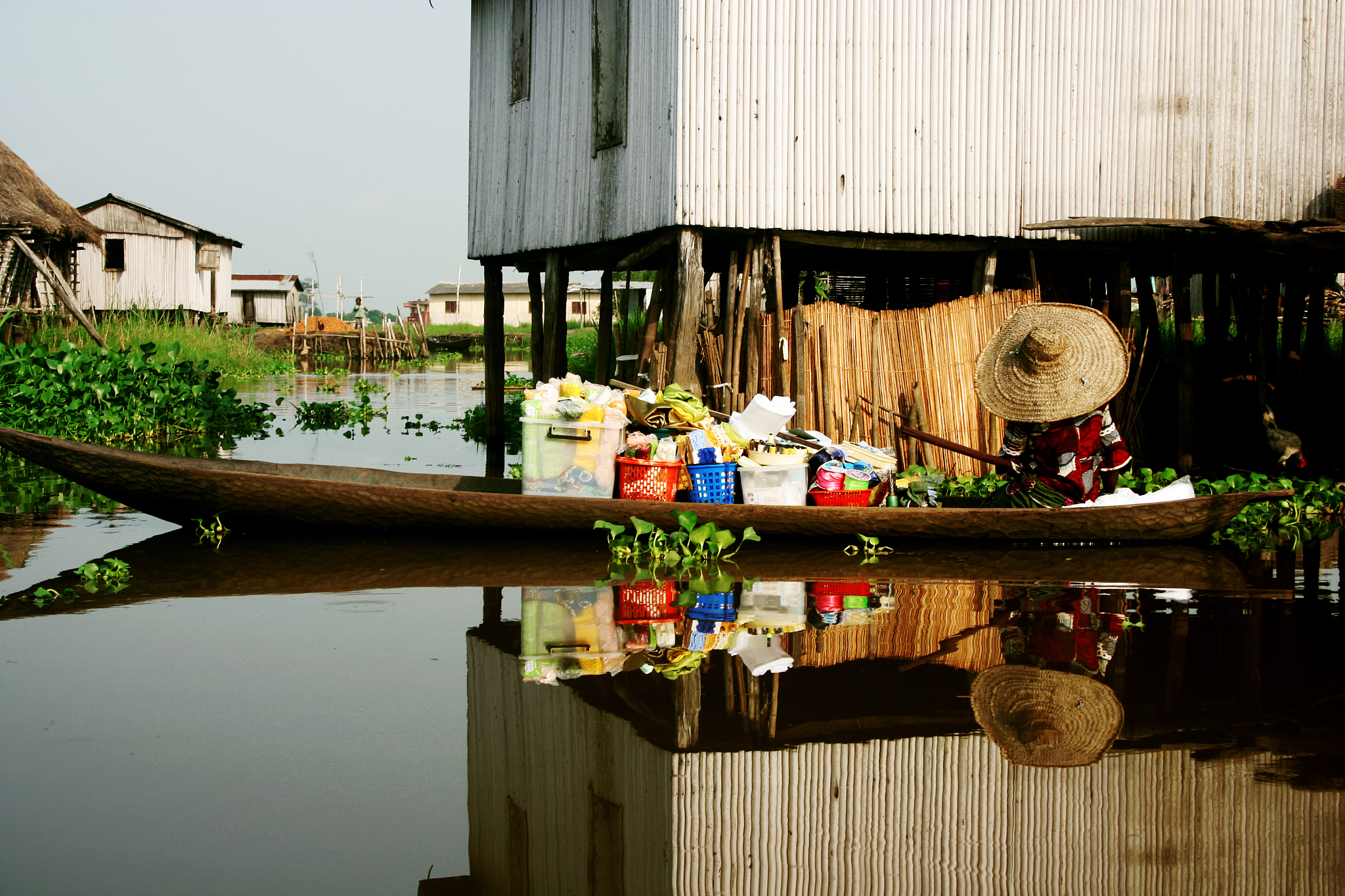 village on water with a person on a long boat