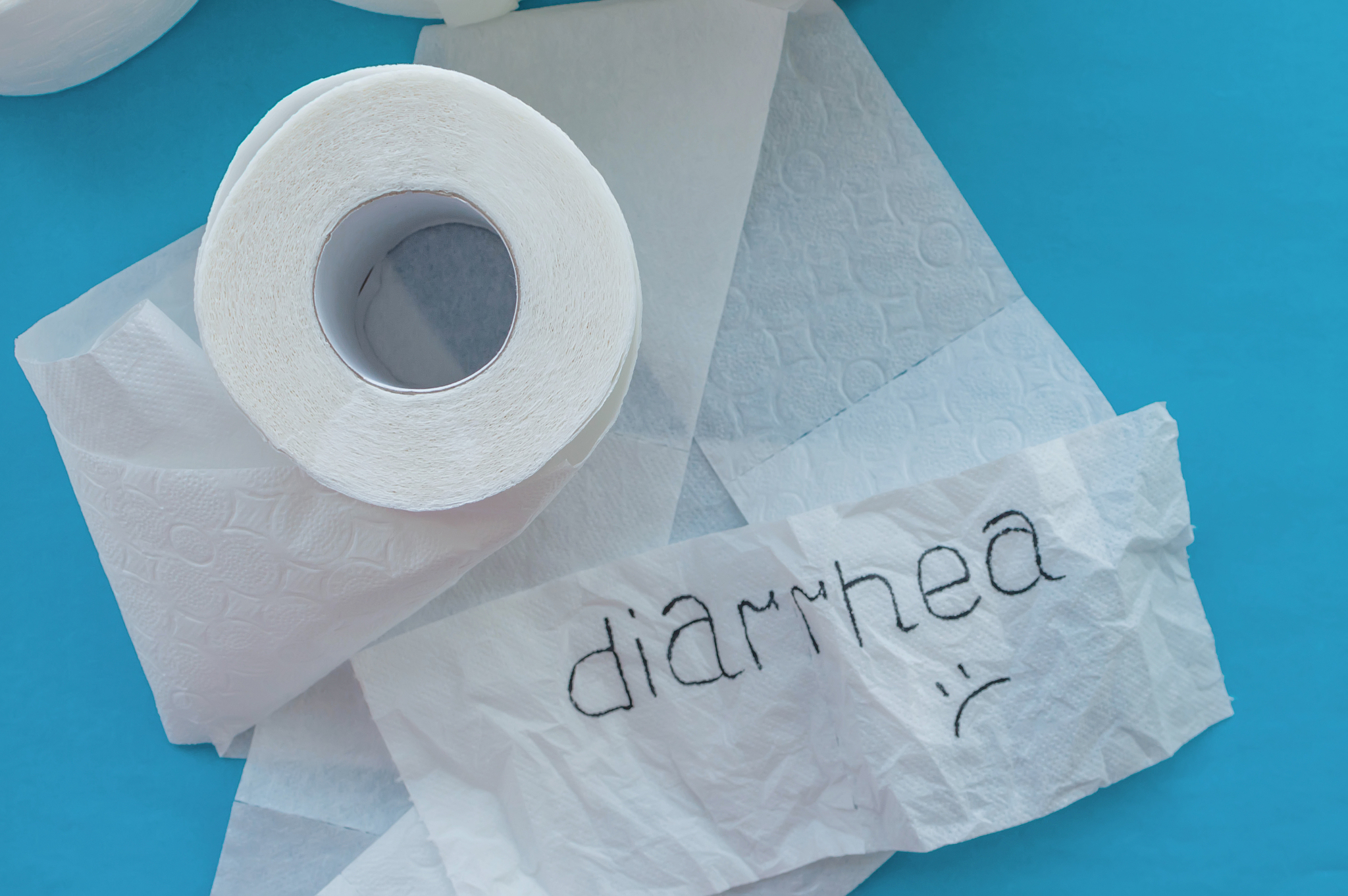 rolls of white toilet paper labeled "diarrhea" on a blue backgro
