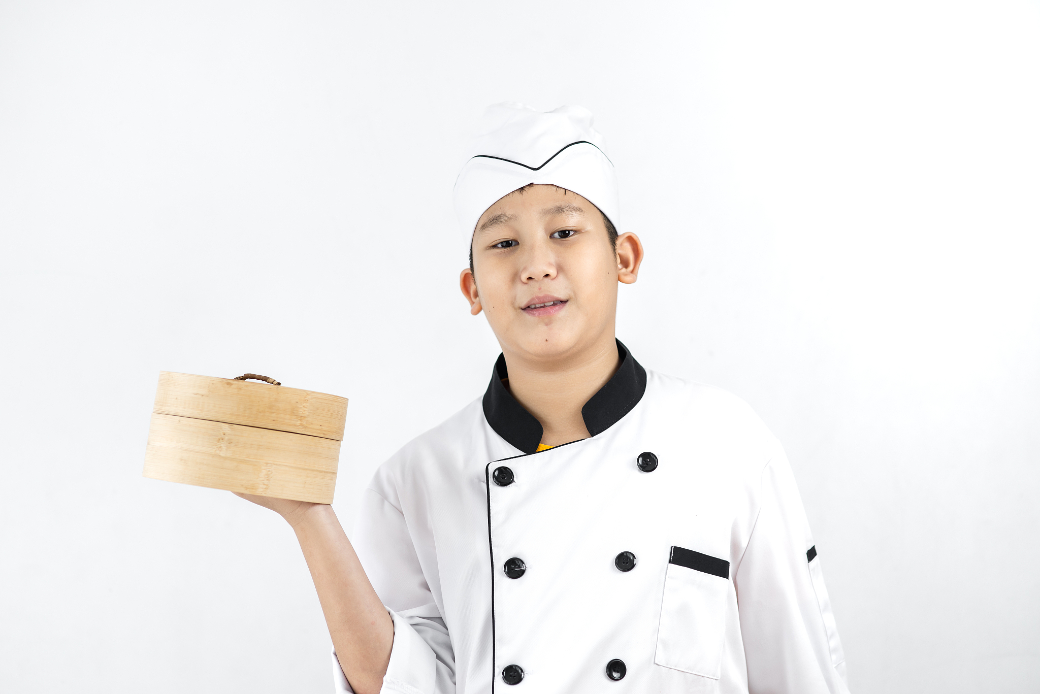 young asian chef holding dumpling in his hand.
