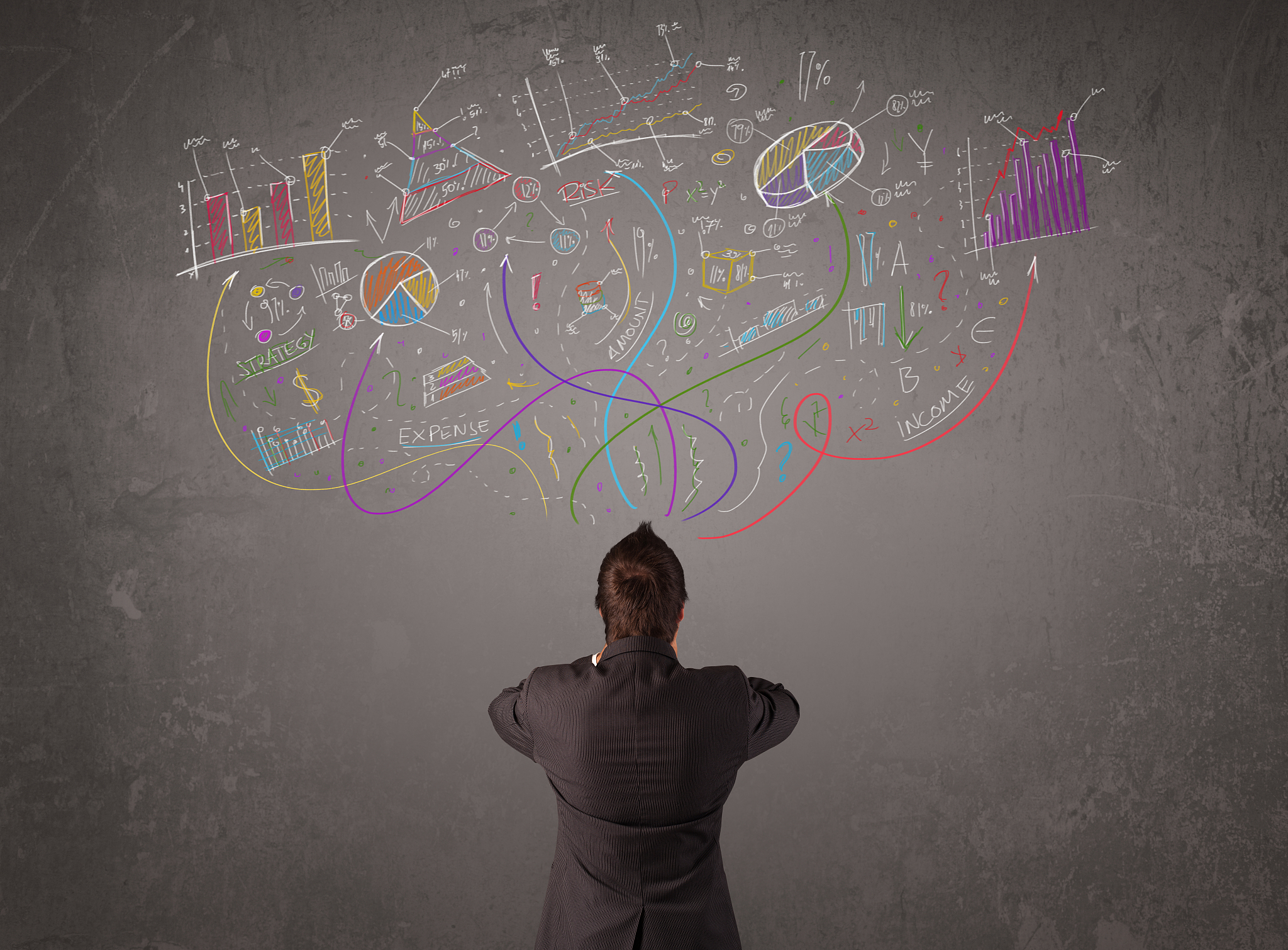 young business man looking at sketches of graphs and symbols