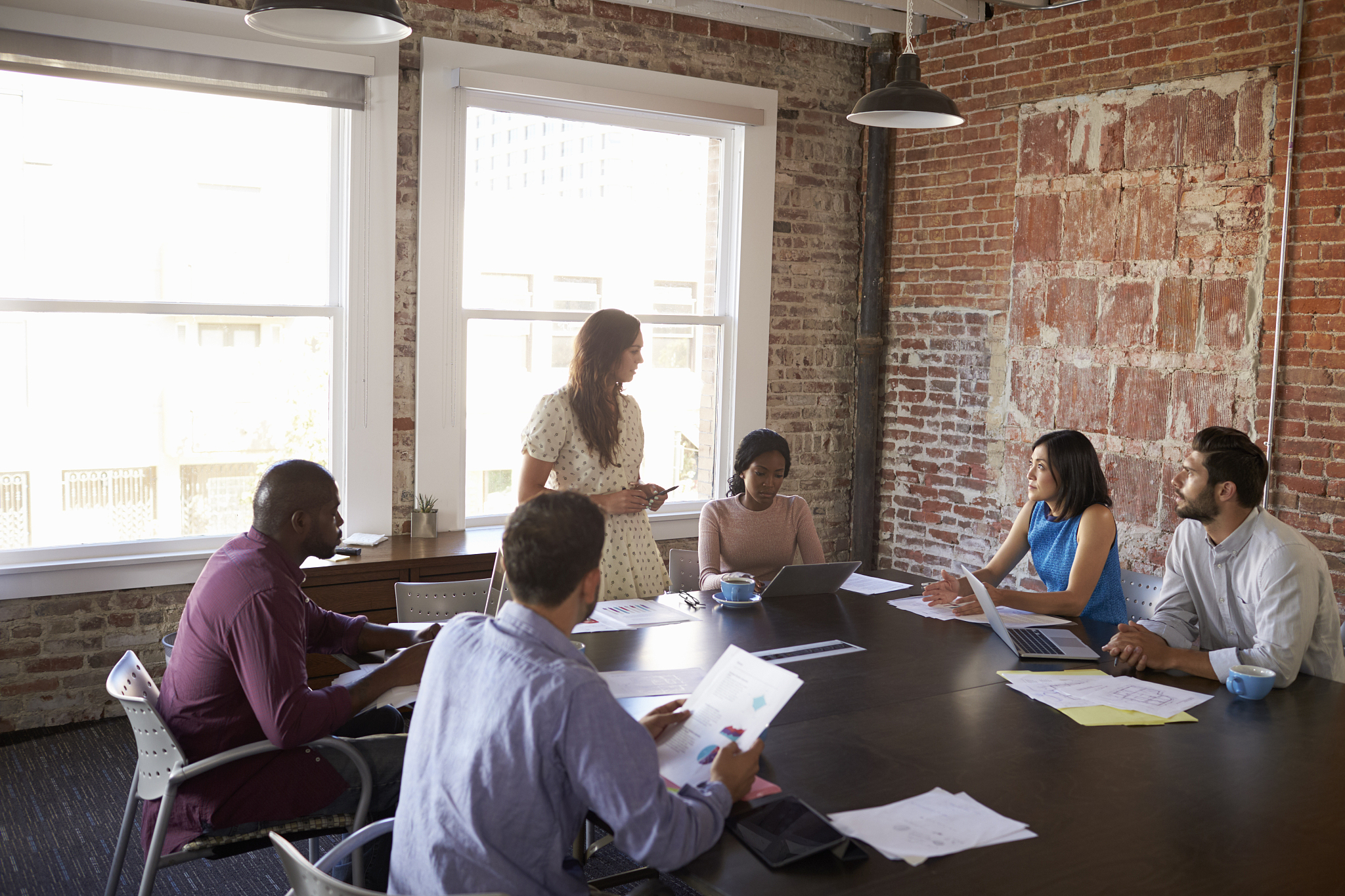 businesswoman standing to address boardroom meeting