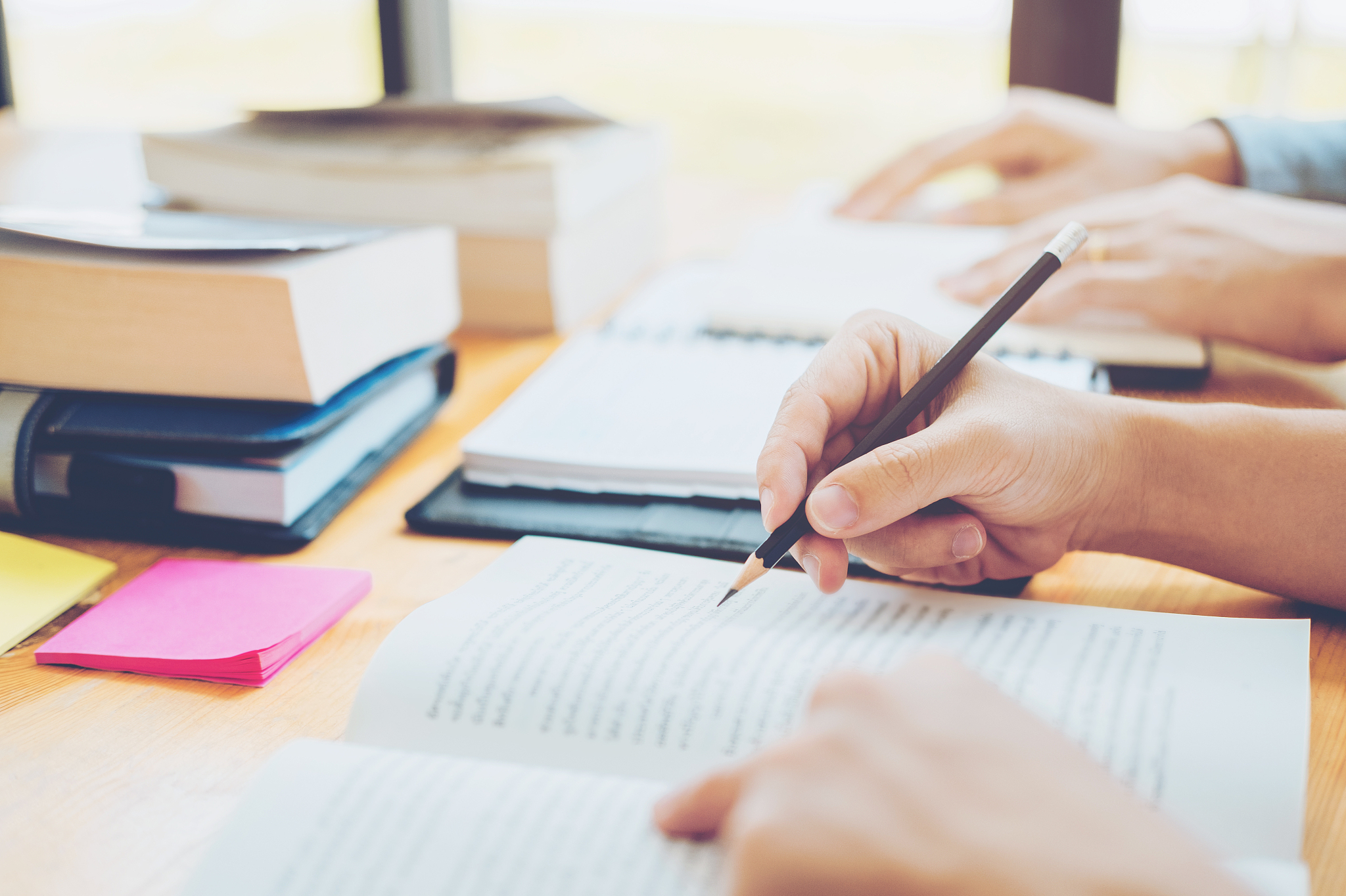 high school or college students studying and reading together in