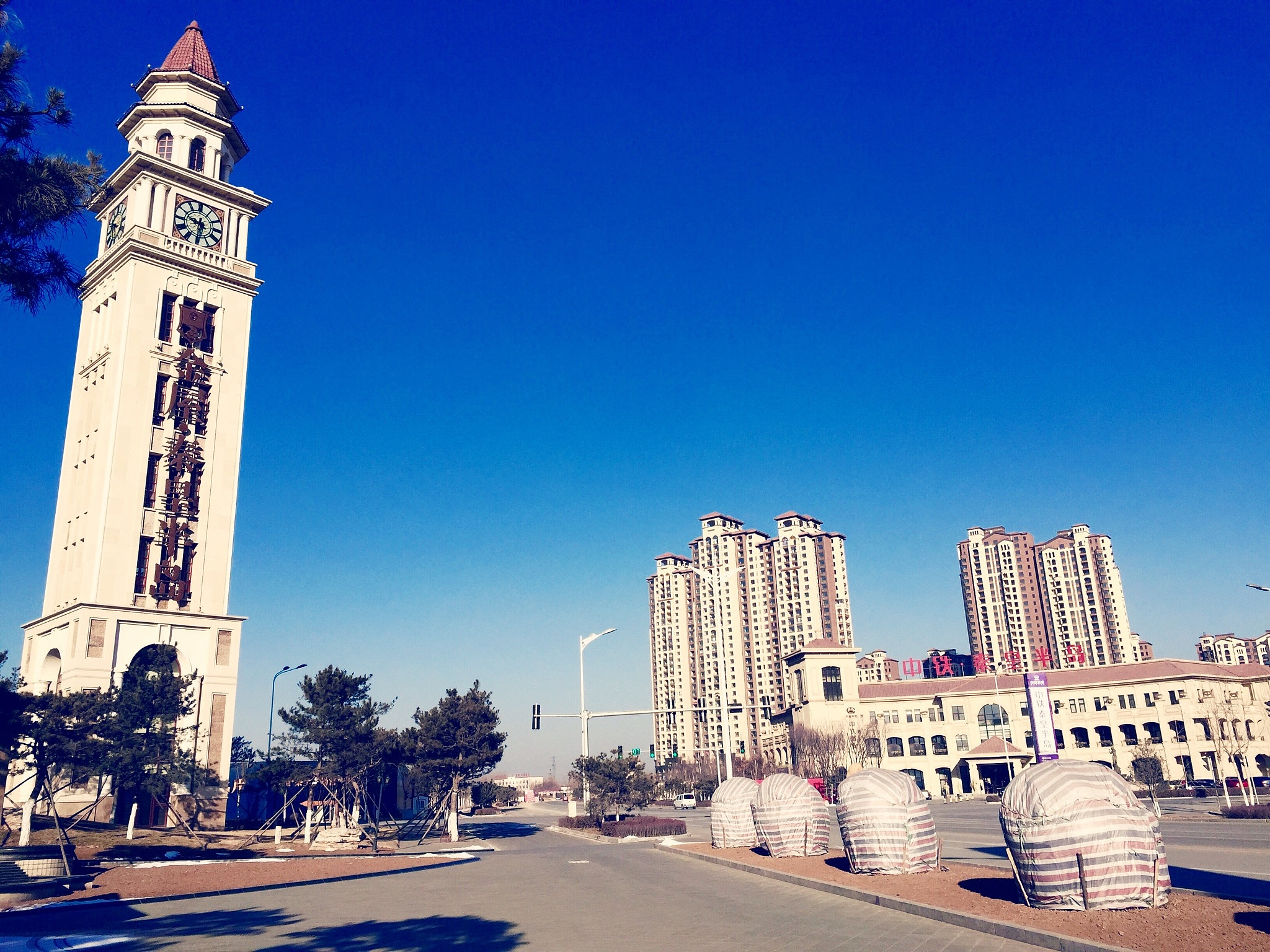 low angle view of clock tower by street against clear blue sky