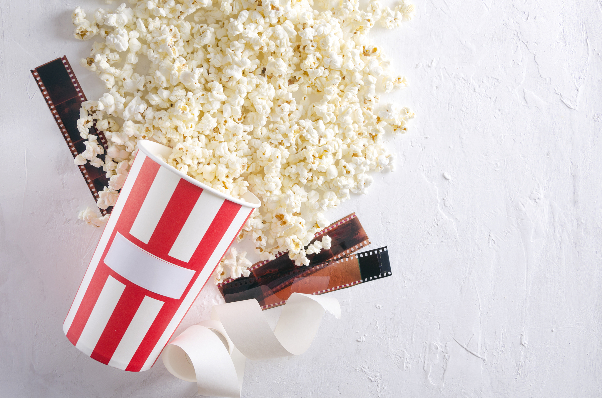 top view of popcorn in a bucket and film stocks, tickets on the 