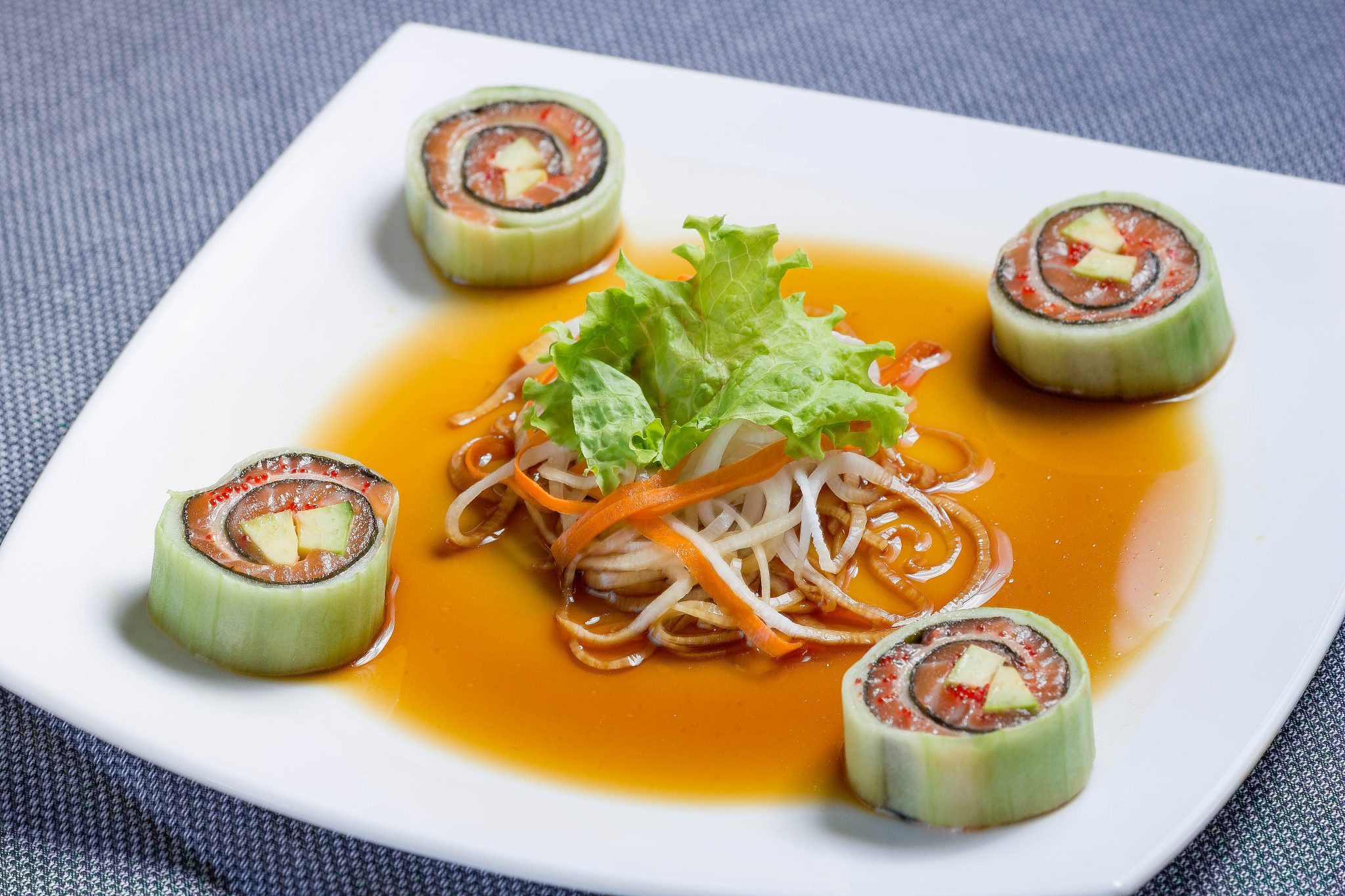 appetizing sushi on a square plate. seafood, fish, greens.