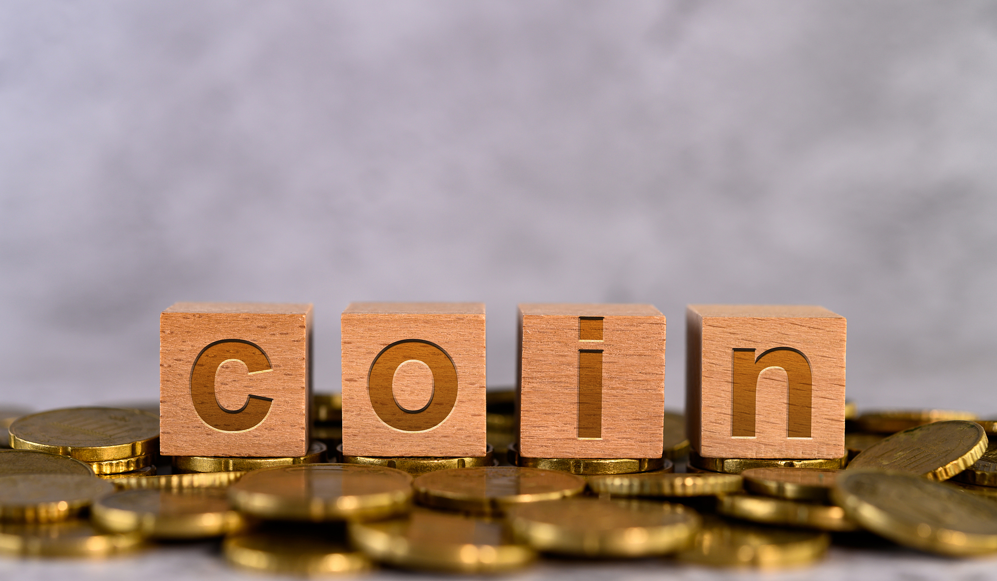 coin word alphabet wooden cube letters placed on a gold coin