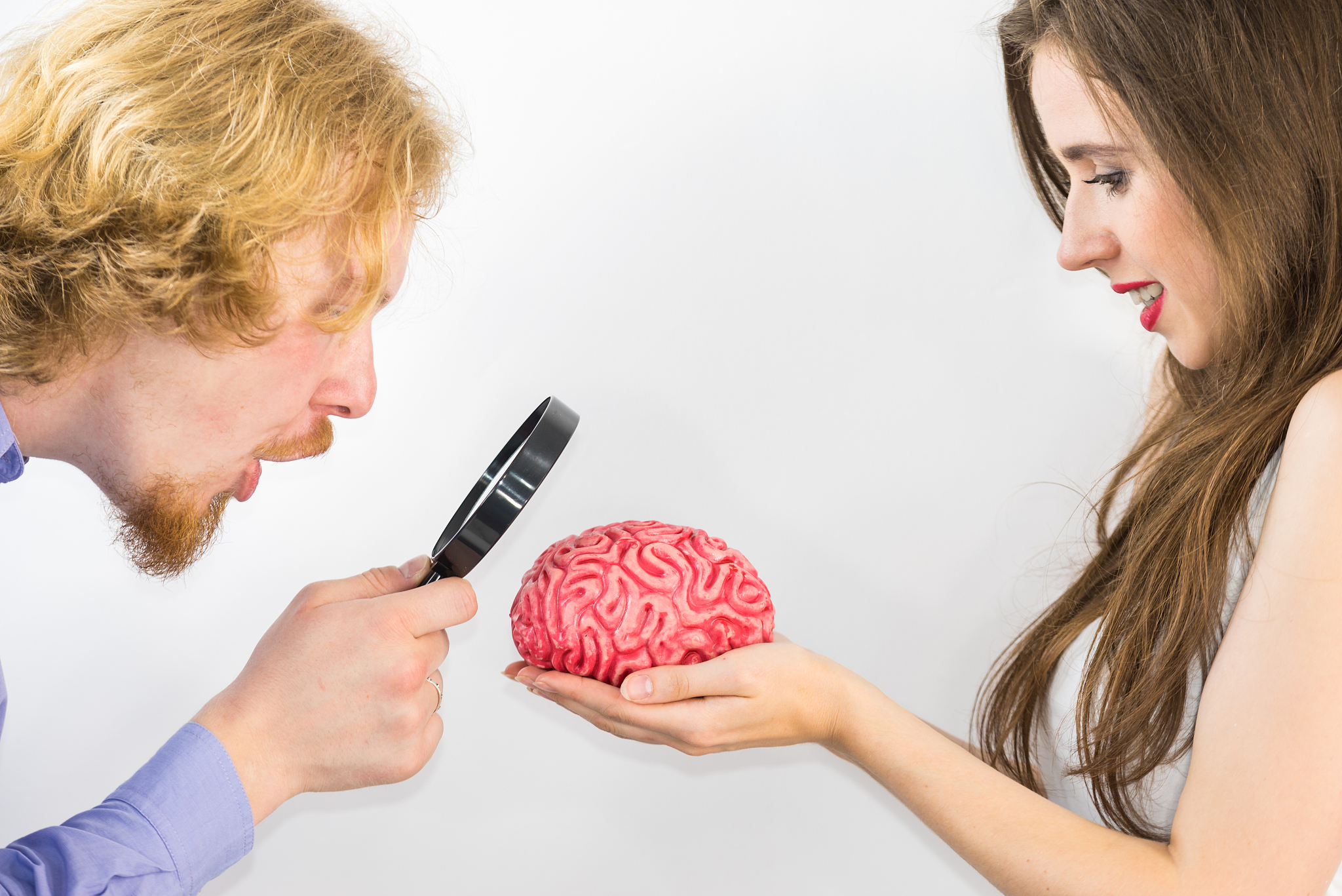 couple using magnifying glass on human brain