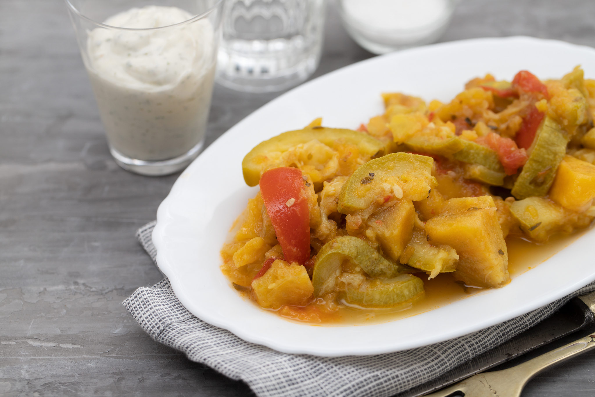 vegetable stew in white dish on ceramic background